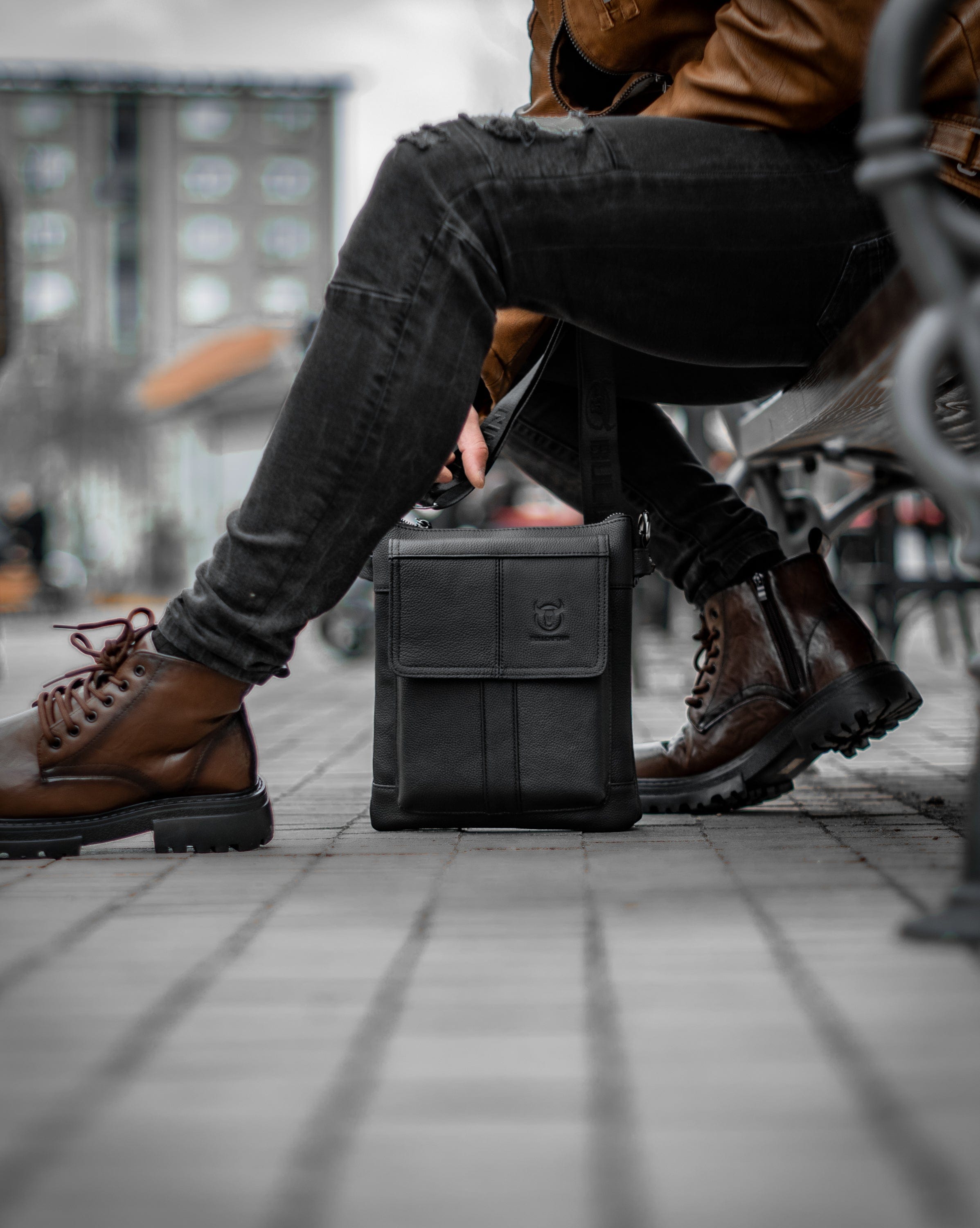 Muška kožna torba Toro - Crna Boja - Muškarac drži u rukama kaiš kožne torbe i pokazuje izbliza prednju stranu