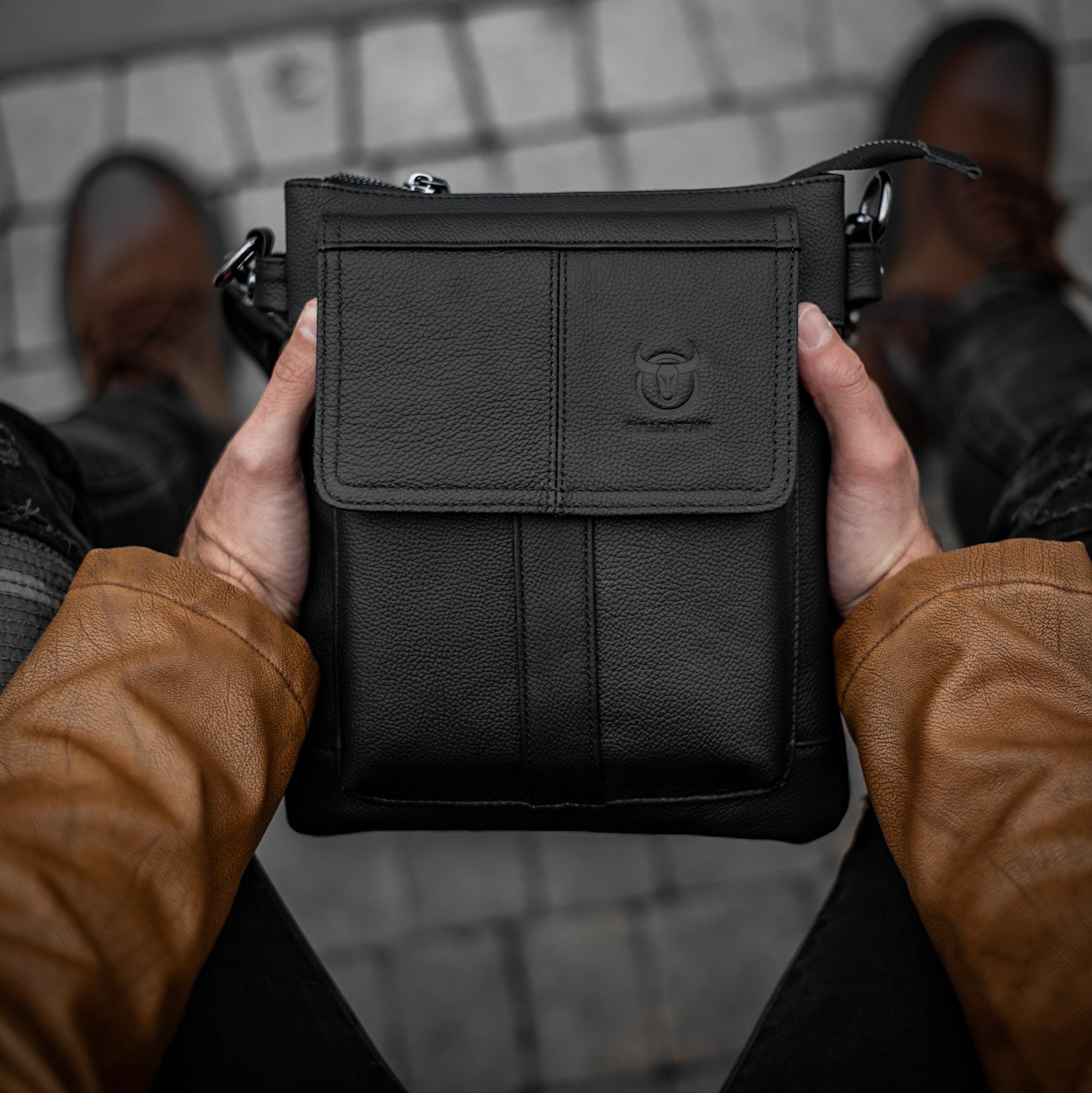 Muška kožna torba Toro - Crna Boja - Muškarac drži u rukama torbu i izbliza pokazuje prednju stranu