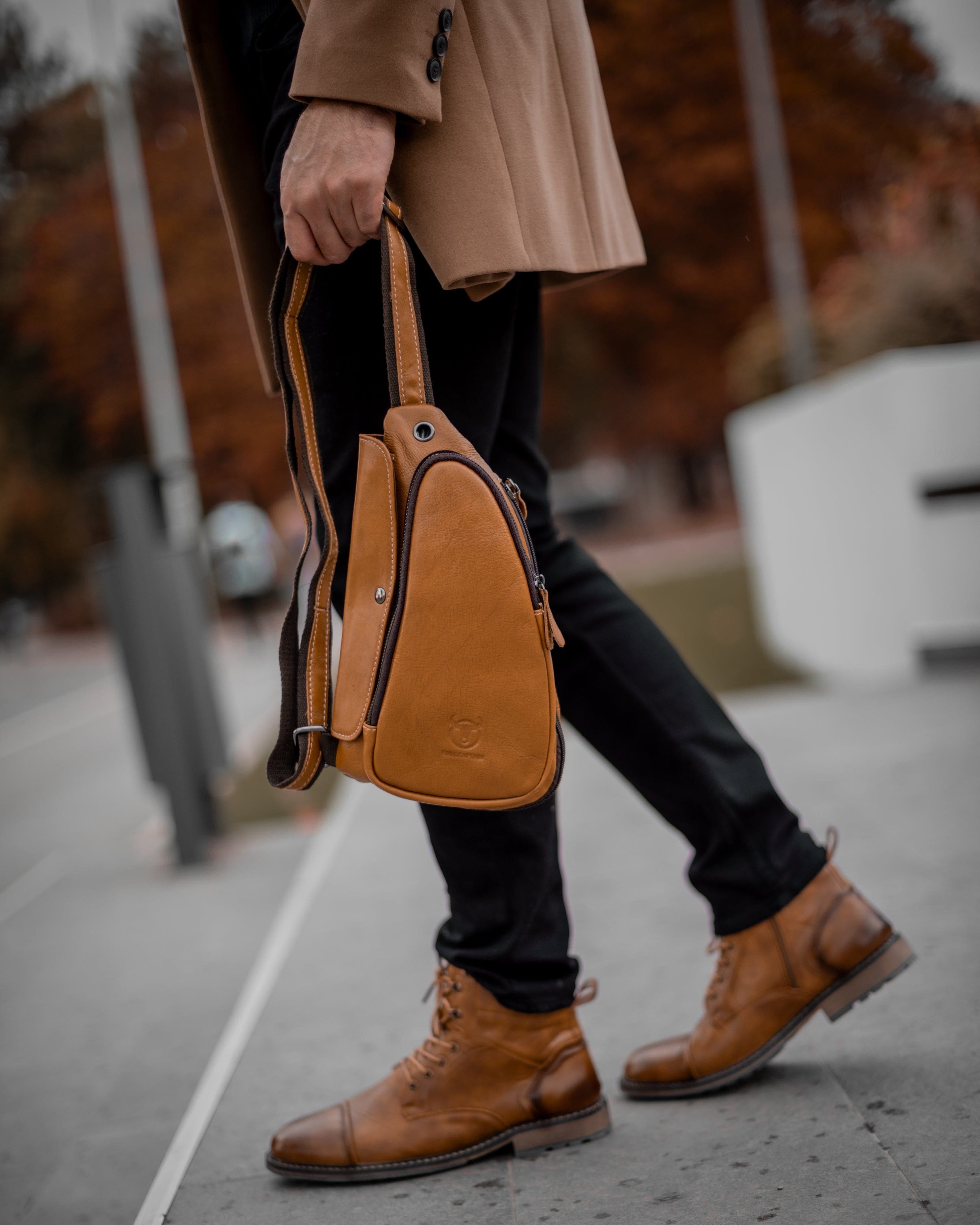 Muskarac drzi u ruci modernu musku koznu torbu Devon u svetlo braon boji, Najbolja cena i prodaja u Srbiji