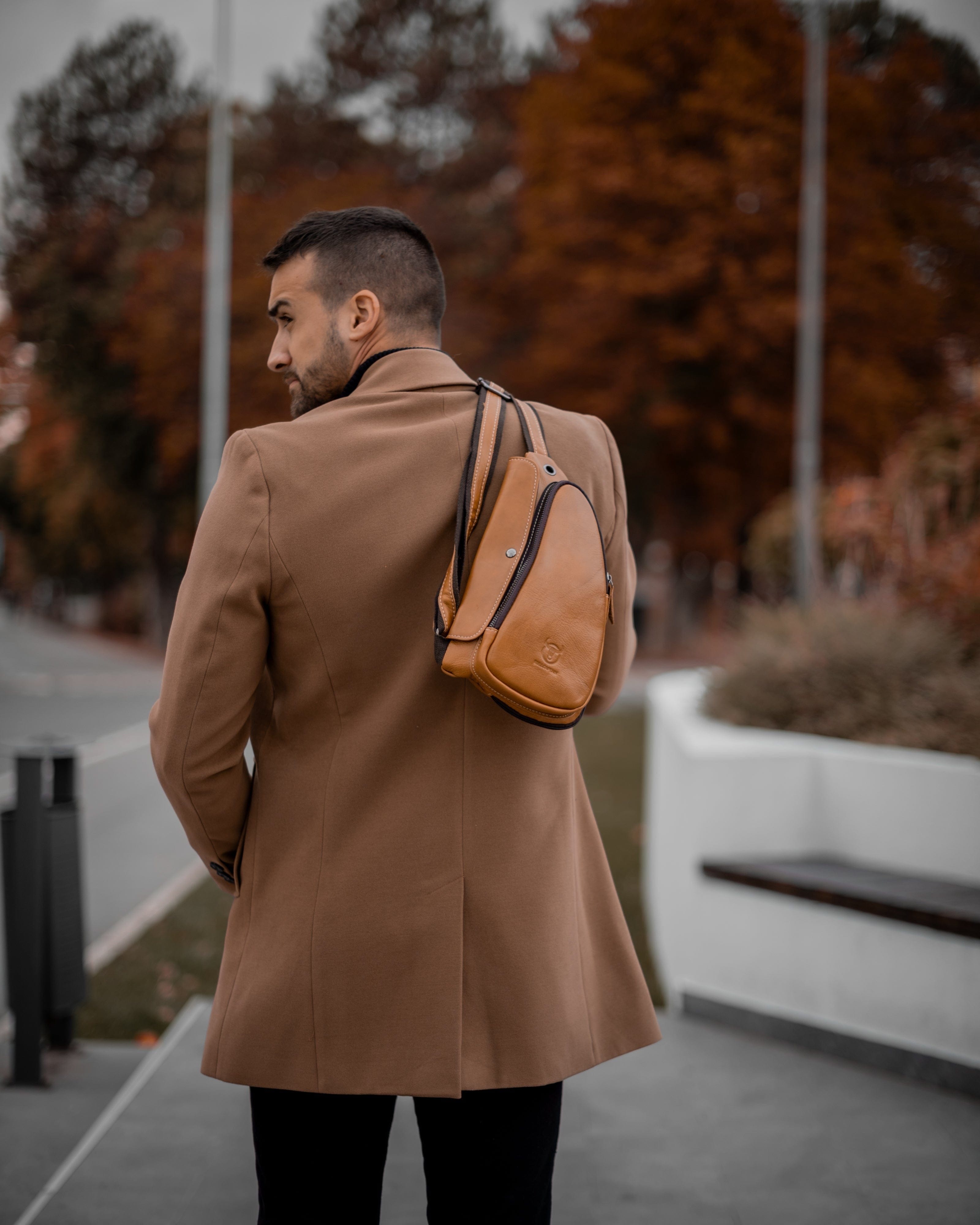 Muskarac nosi na ledjima modernu musku koznu torbu Devon u svetlo braon boji, Najbolja cena i prodaja u Srbiji