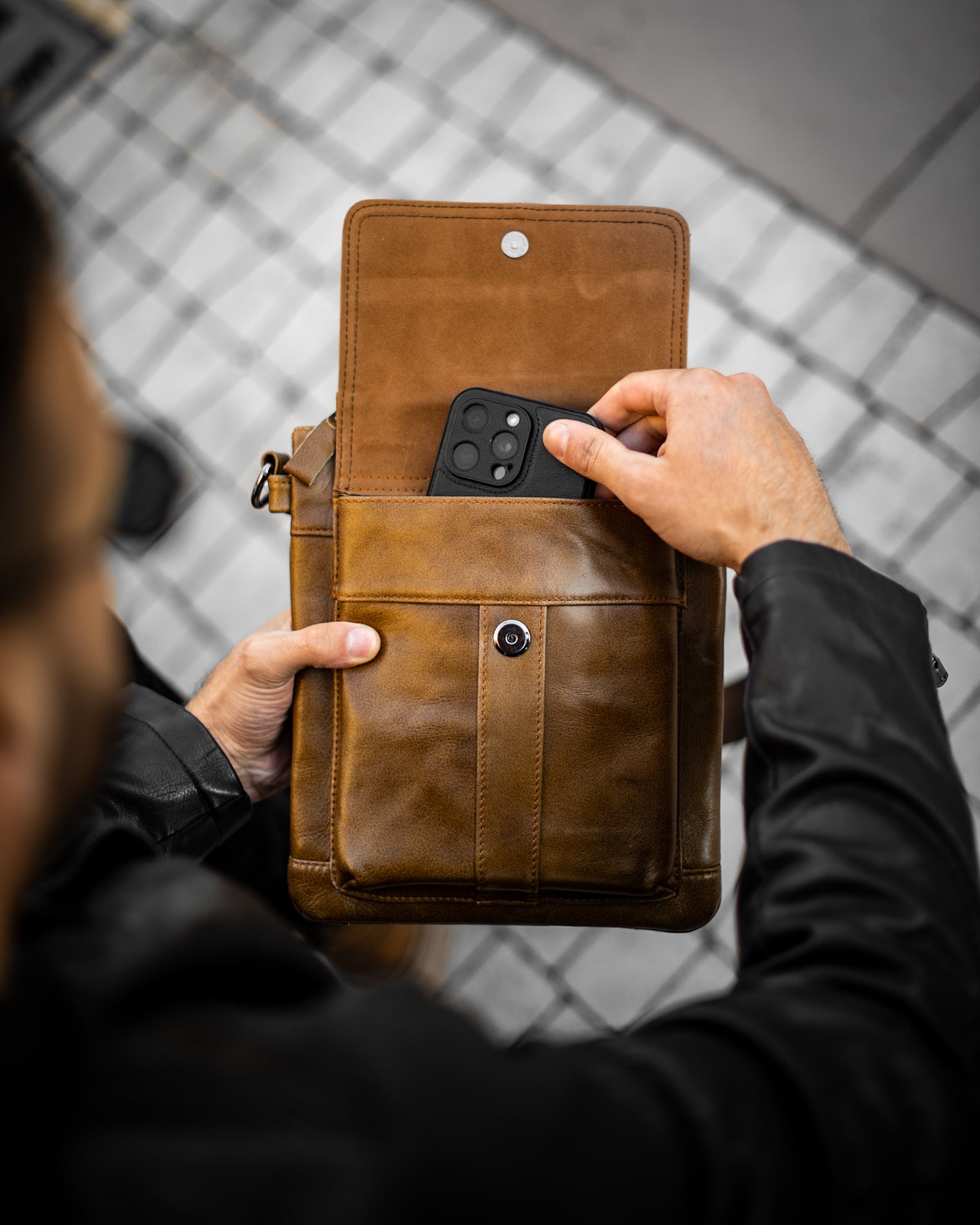 Muška kožna torba Lion - Svetla Braon Boja - Muškarac drži torbu i pokazuje prednju otvorenu  stranu