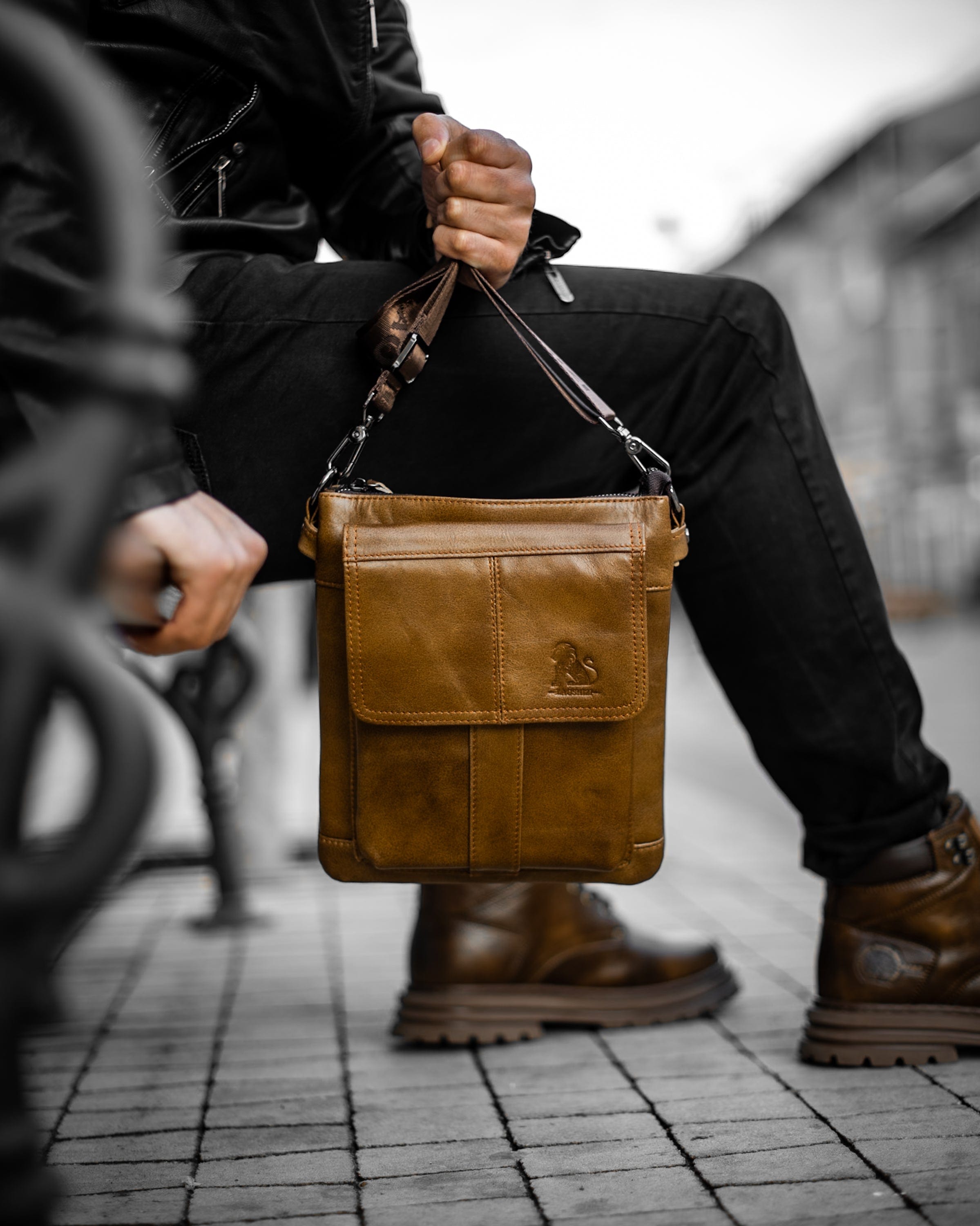 Muška kožna torba Lion  - Svetla Braon Boja - Muškarac drži u ruci torbu i pokazuje prednju stranu