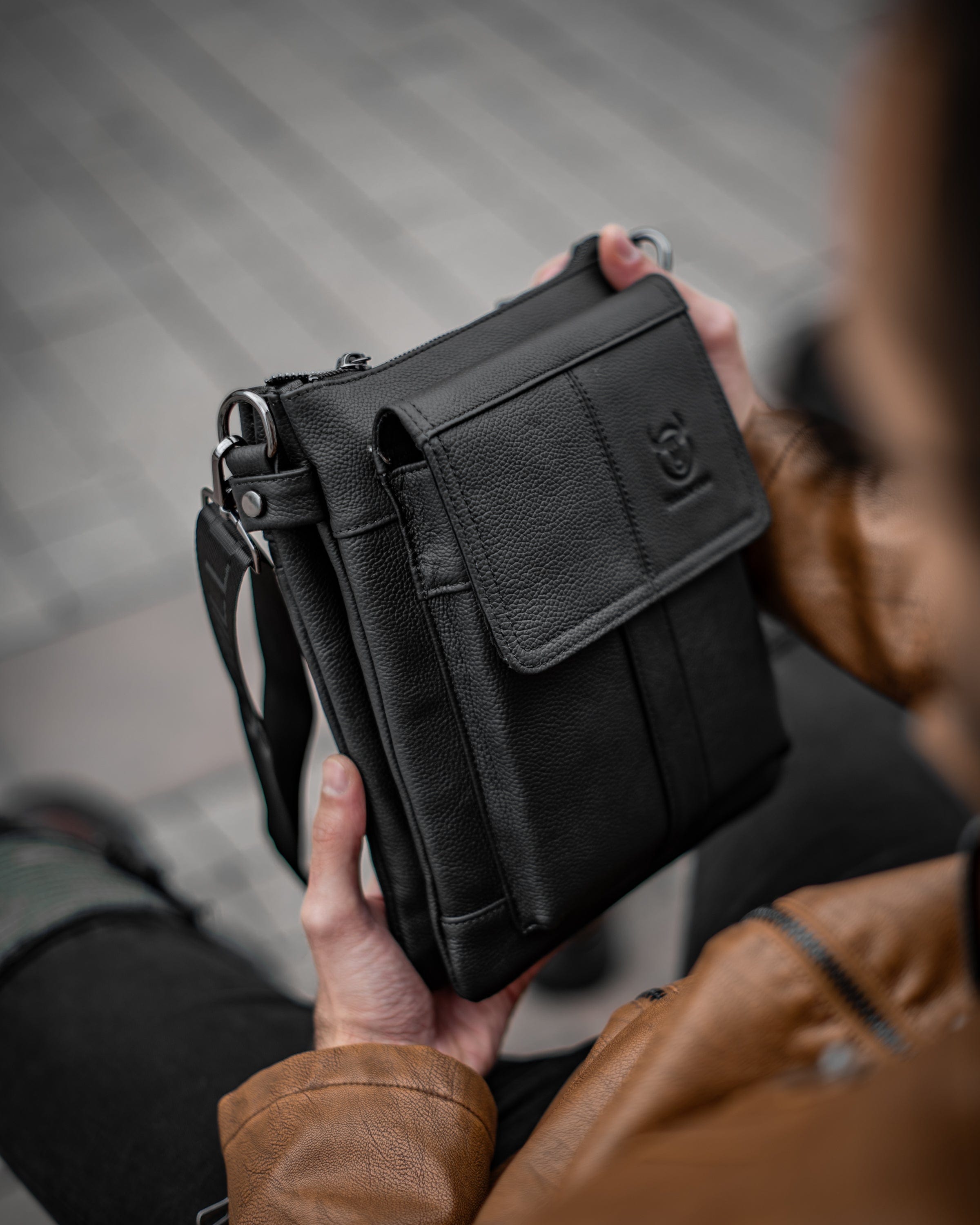 Muška kožna torba Toro - Crna Boja - Muškarac drži u rukama torbu i pokazuje prednju bočnu stranu