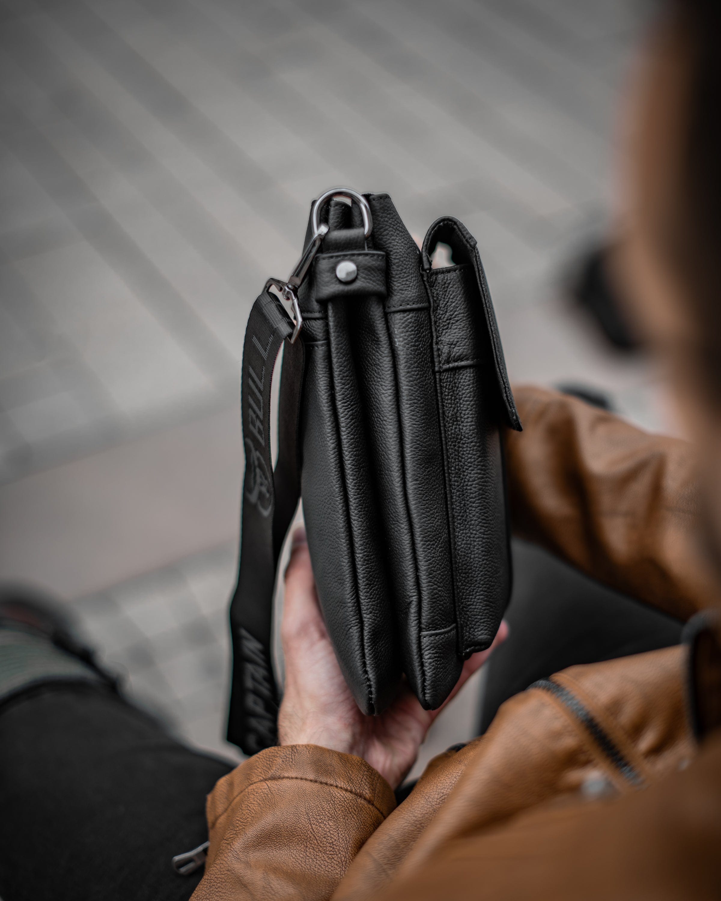 Muška kožna torba Toro - Crna Boja - Muškarac drži u rukama torbu i pokazuje desnu stranu