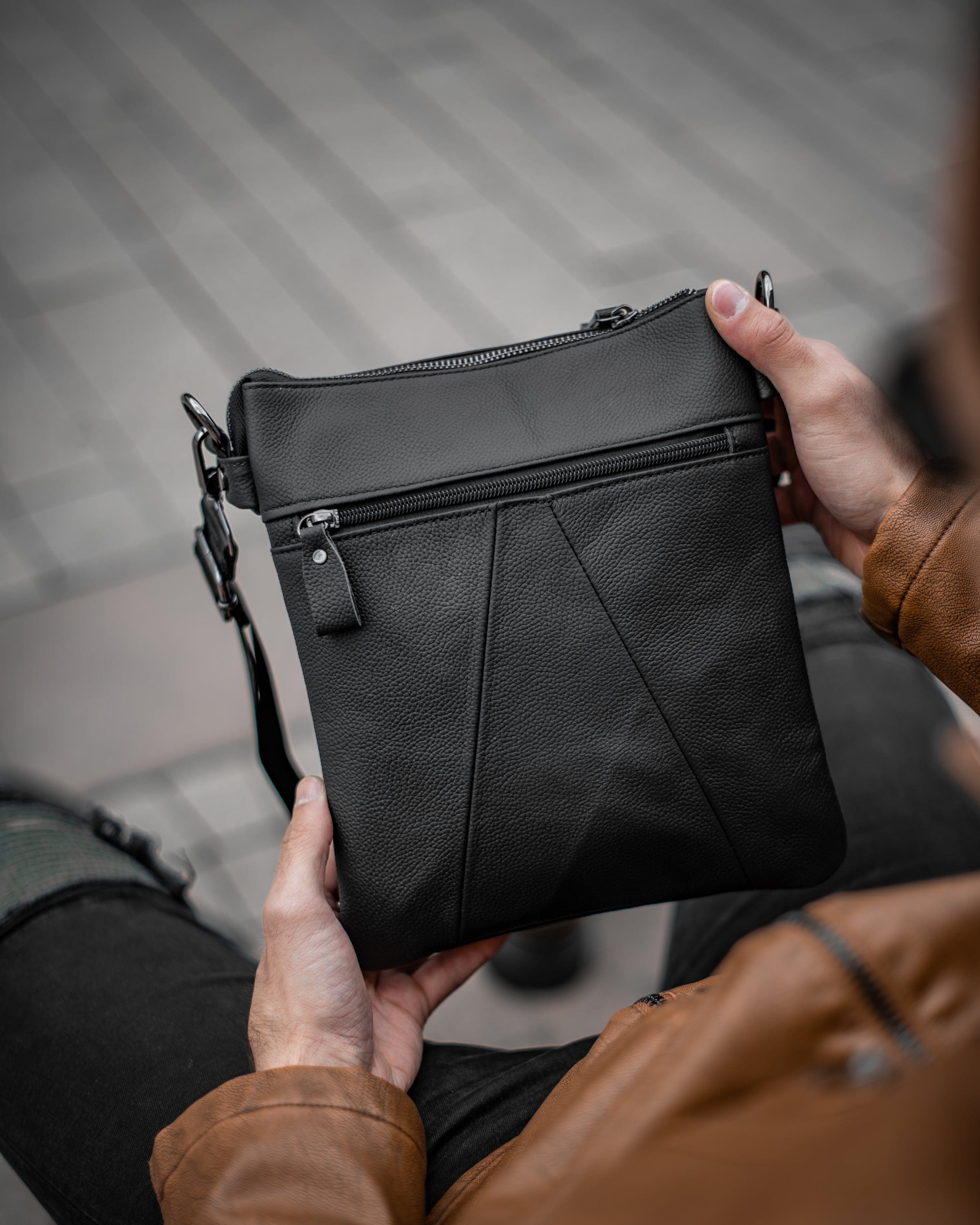 Muška kožna torba Toro - Crna Boja - Muškarac drži u rukama torbu i pokazuje zadnju stranu