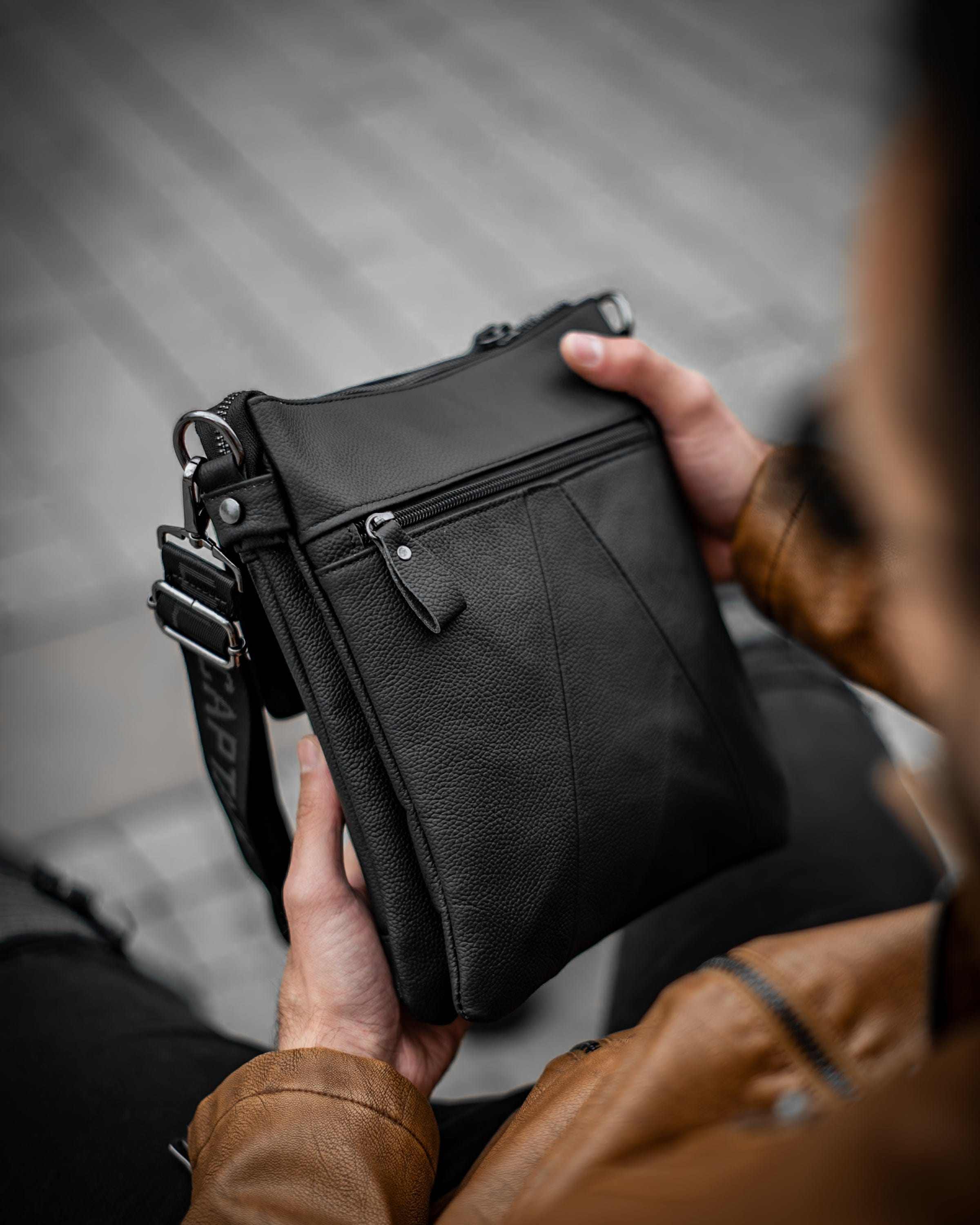 Muška kožna torba Toro - Crna Boja - Muškarac drži u rukama torbu i pokazuje zadnju bočnu stranu