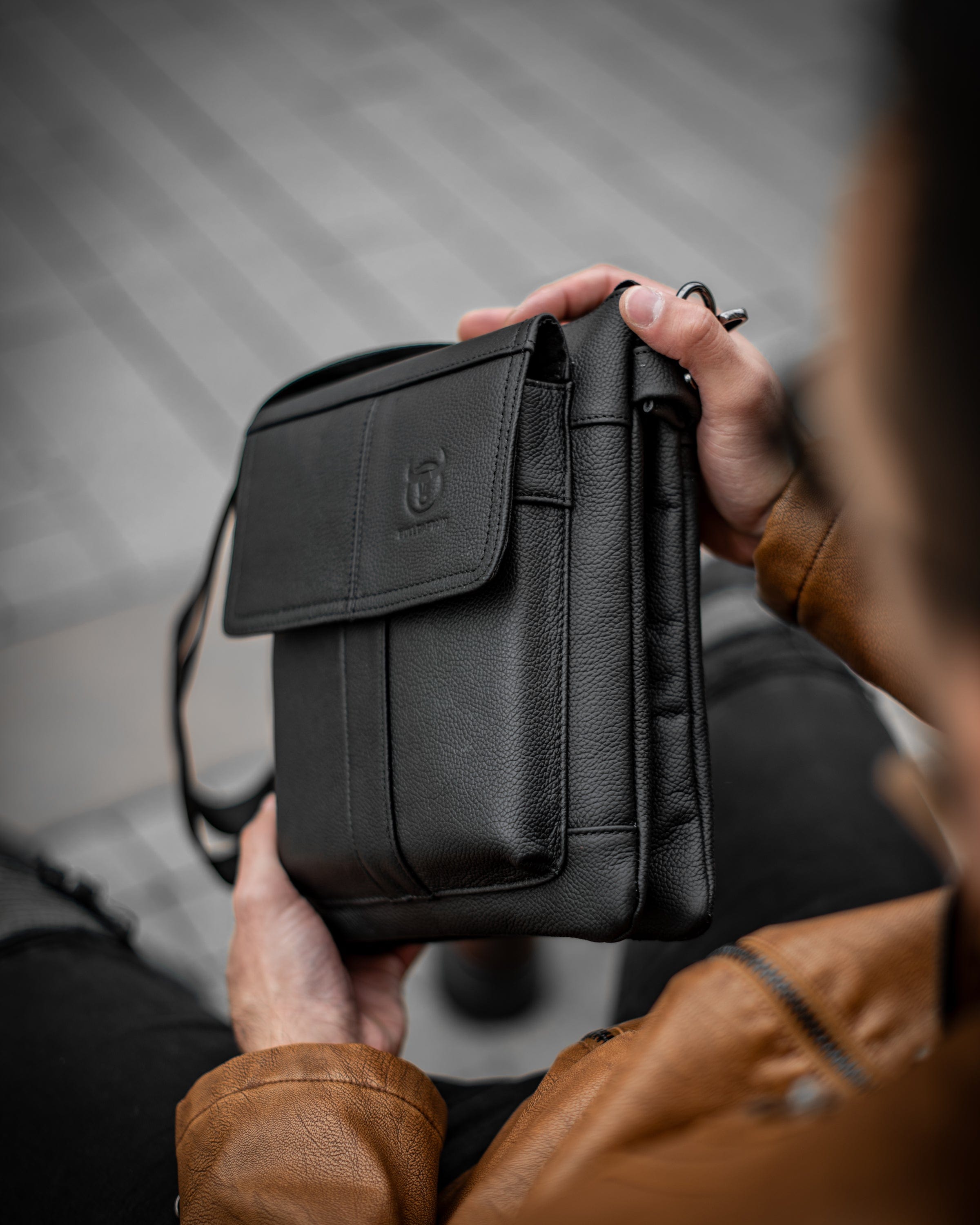 Muška kožna torba Toro - Crna Boja - Muškarac drži u rukama torbu i pokazuje prednju levu stranu