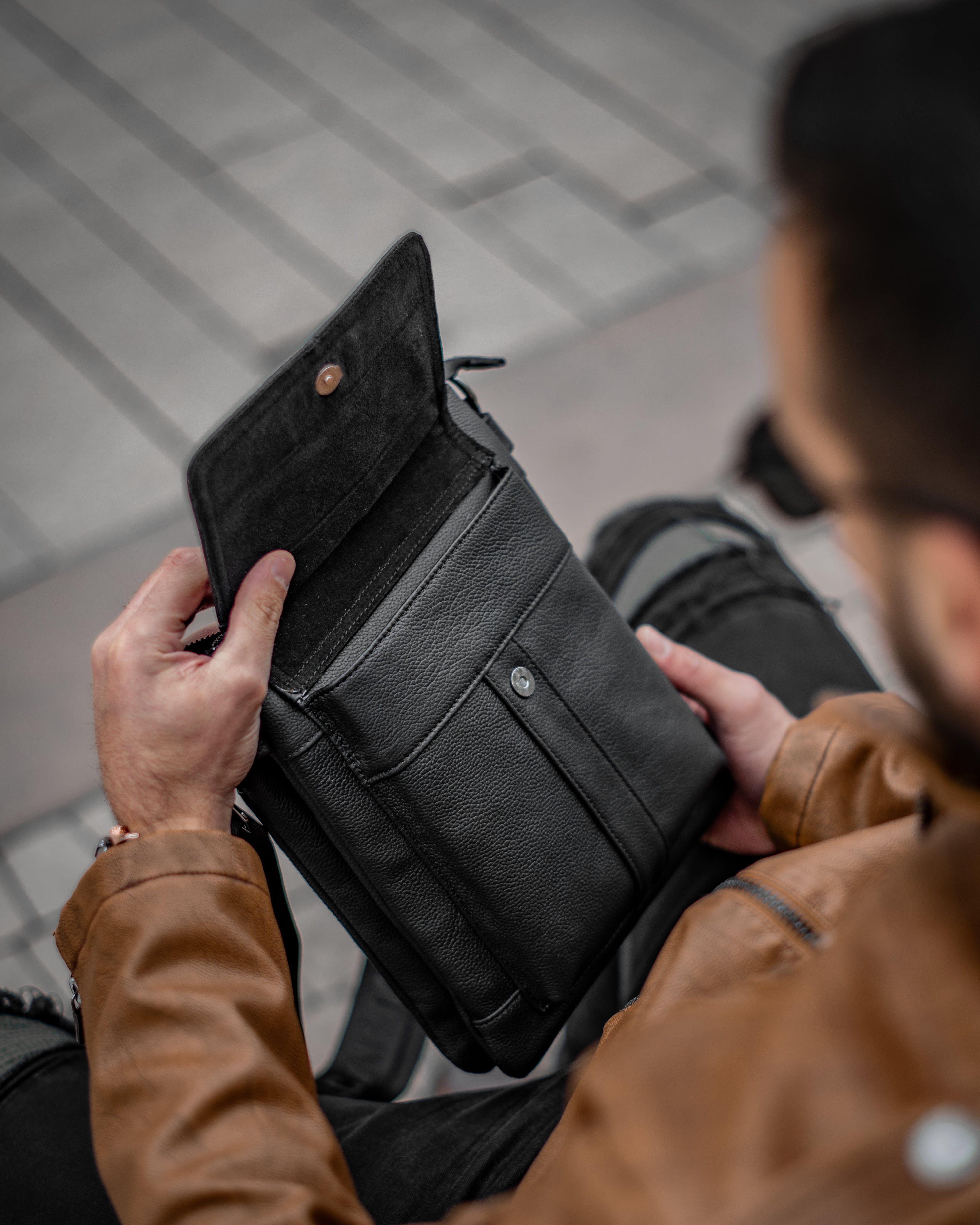 Muška kožna torba Toro - Crna Boja - Muškarac drži u rukama torbu i pokazuje prednju otvorenu stranu