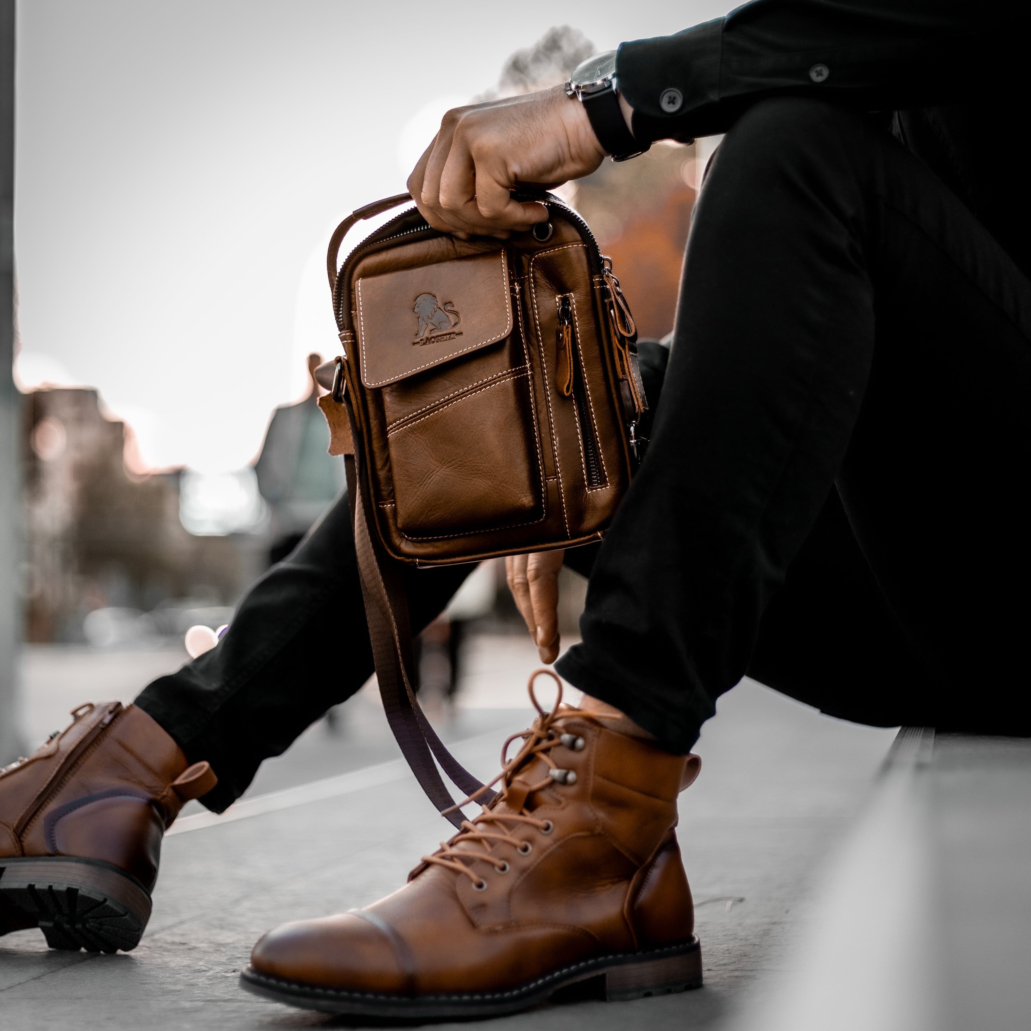 Muskarac drzi u rukama modernu musku koznu torbu Leo u braon boji. Najbolja cena i prodaja u Srbiji, Model 4