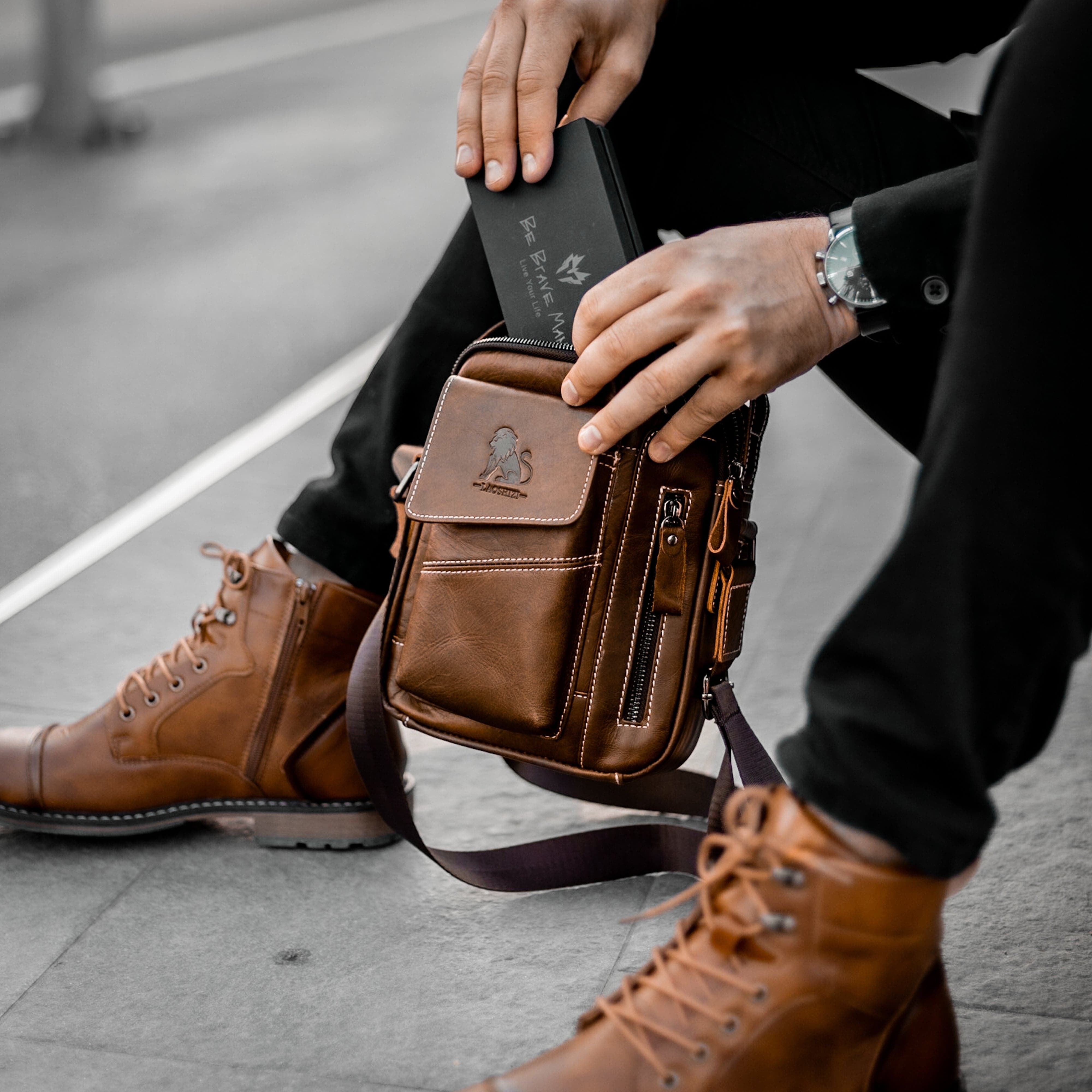 Muskarac drzi u rukama i pokazuje prednju stranu moderne muske kozne torbe Leo u braon boji, najbolja cena i prodaja u Srbiji, model 4