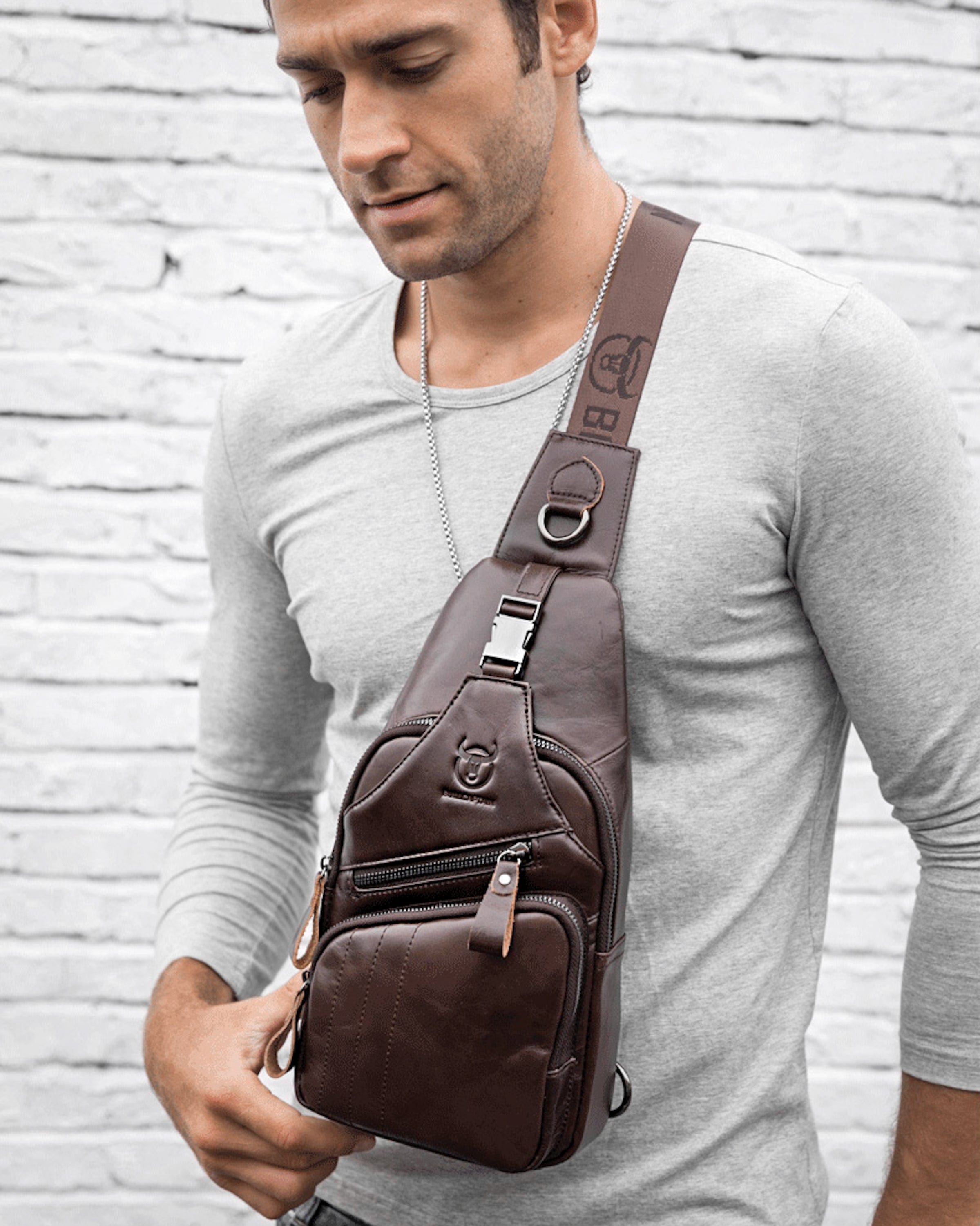 Muška Kožna Torba Tour - Tamna Braon Boja - Muškarac nosi torbu preko grudi i pokazuje prednju stranu torbe