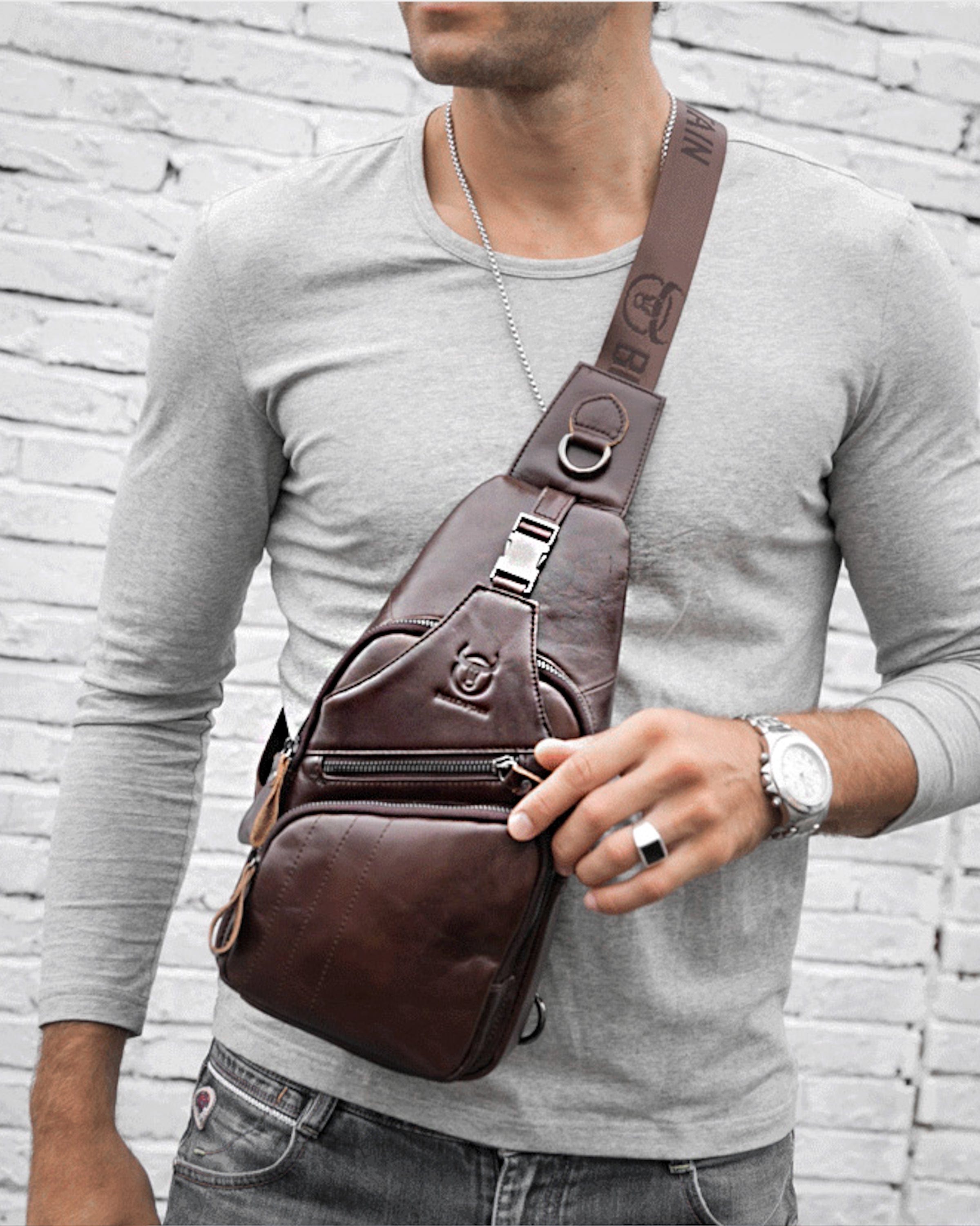Muška Kožna Torba Tour - Tamna Braon Boja - Muškarac nosi torbu preko ramena i pokazuje prednju stranu torbe