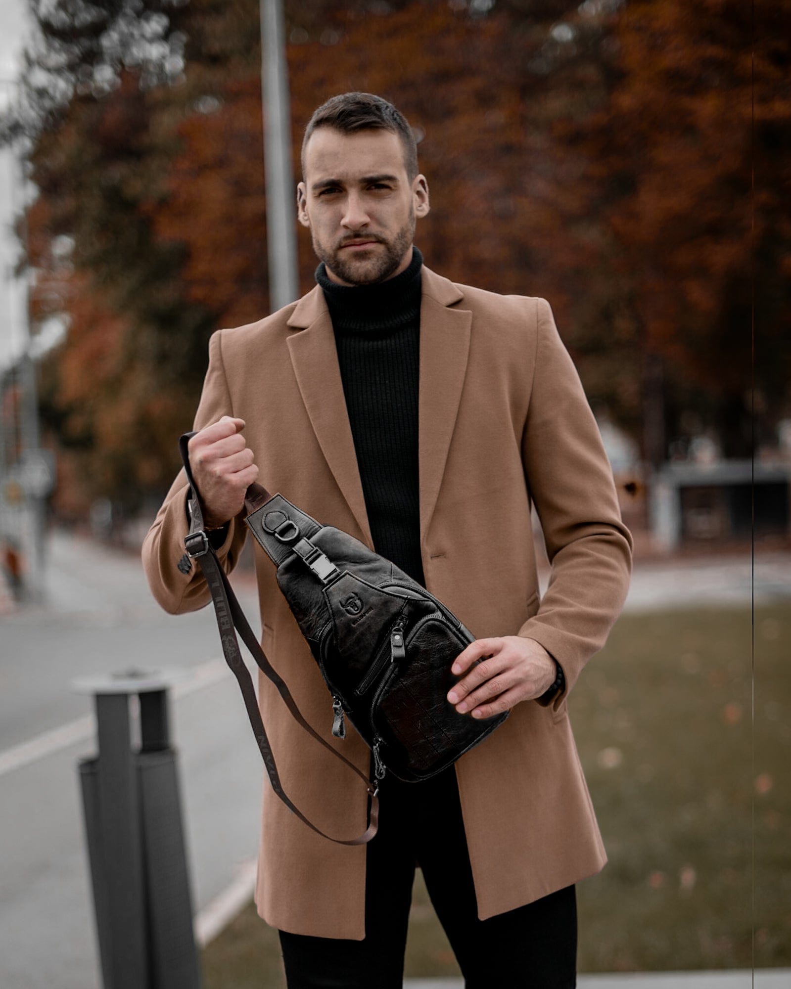 Muška Kožna Torba Tour - Crna Boja - Muskarac drzi u rukama torbu i pokazuje prednju stranu