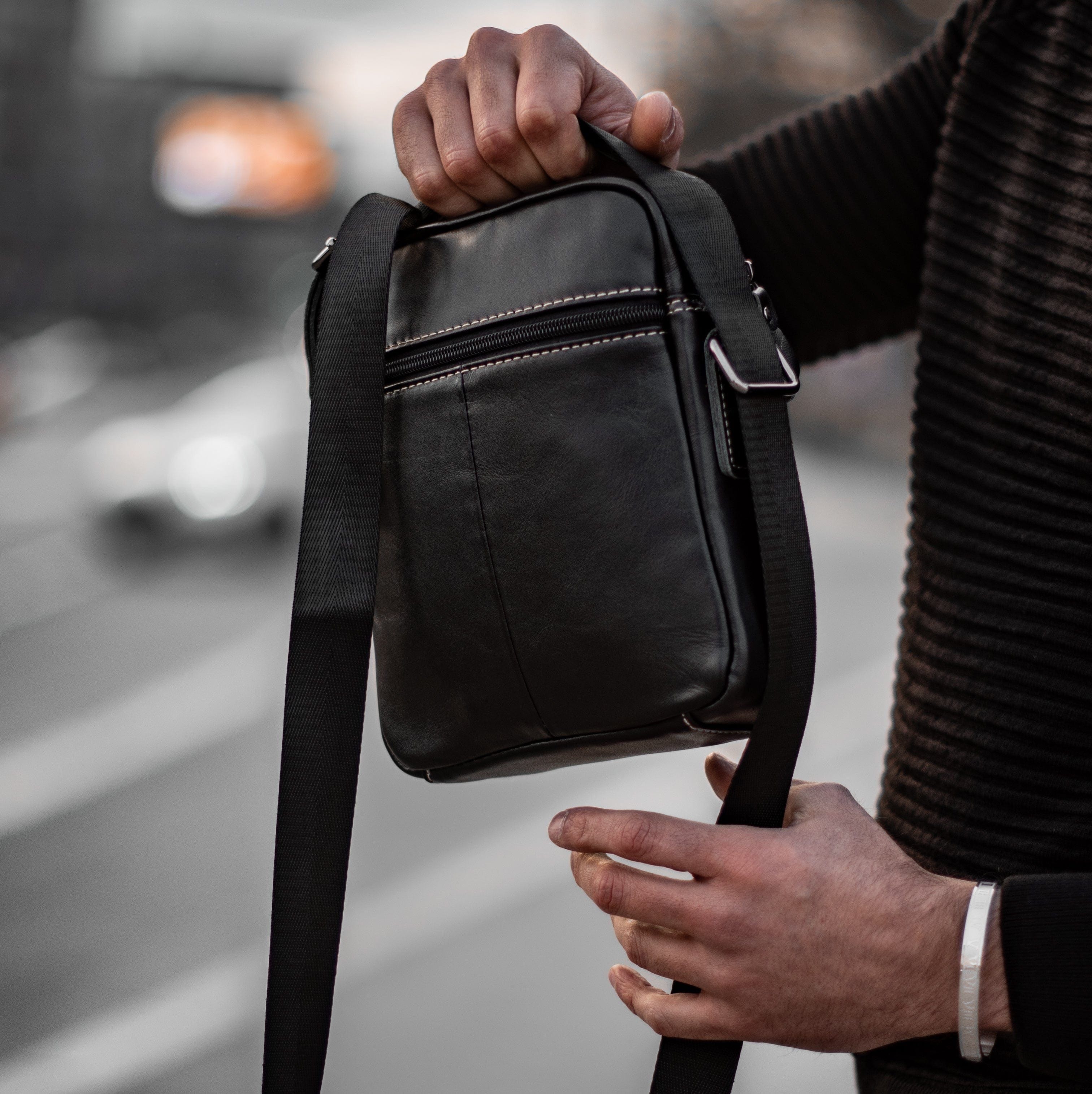 Muška Kožna Torba Leo - Crna Boja - Muskarac drzi u rukama torbu i pokazuje zadnju stranu