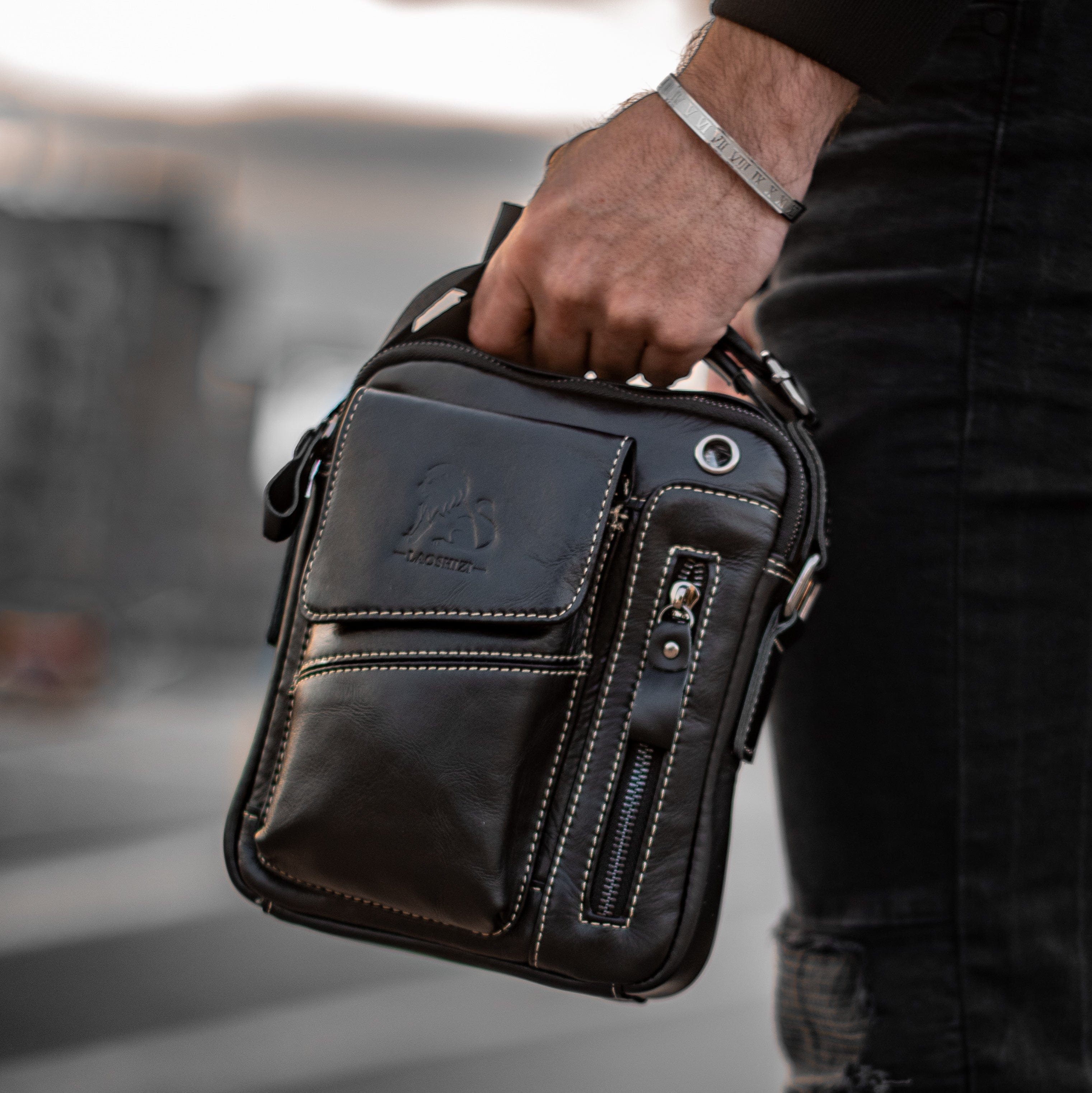 Muška Kožna Torba Leo - Crna Boja - Muskarac drzi u ruci torbu i izbliza pokazuje prednju stranu