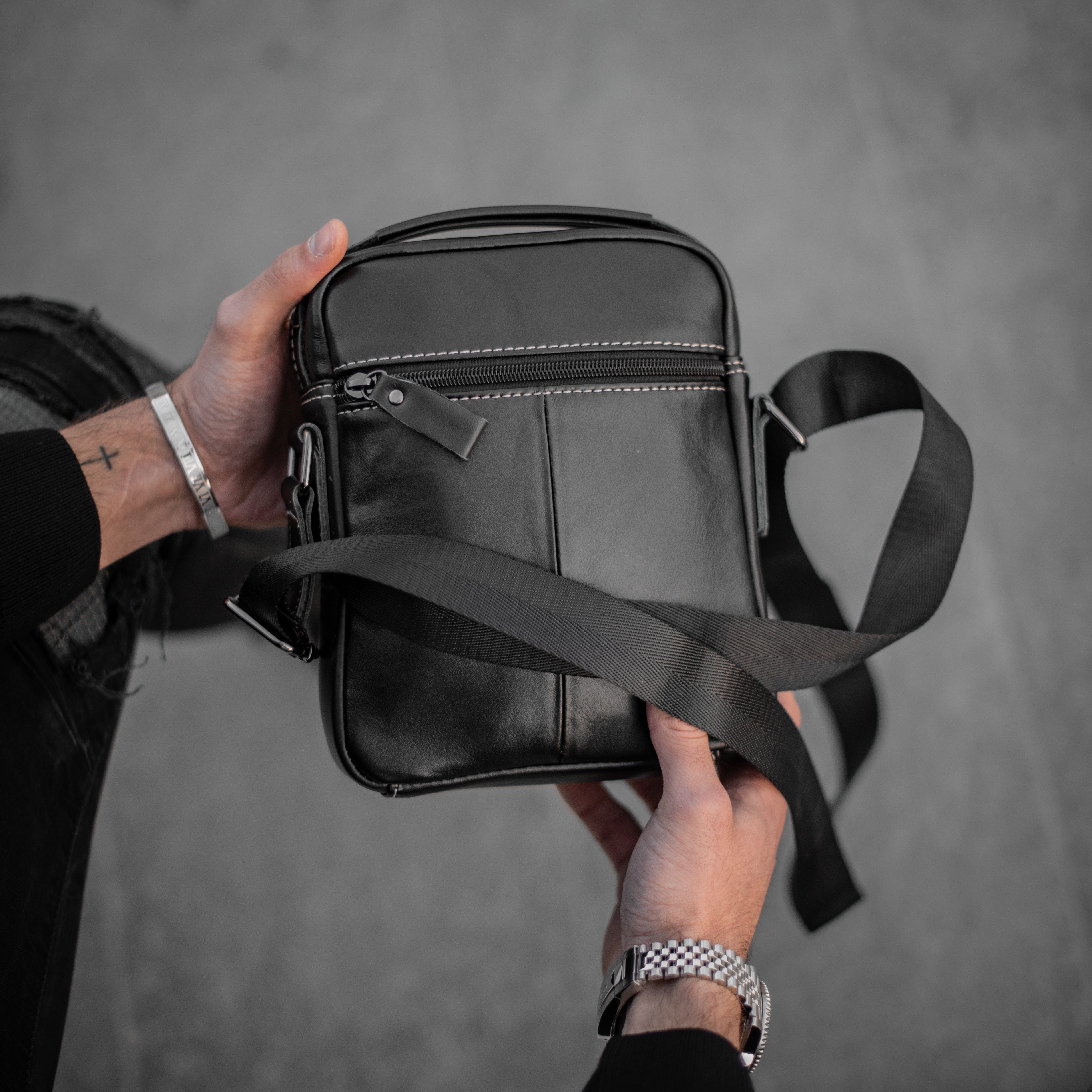 Muška Kožna Torba Leo - Crna Boja - Muskarac drzi u rukama torbu i izbliza pokazuje zadnju stranu
