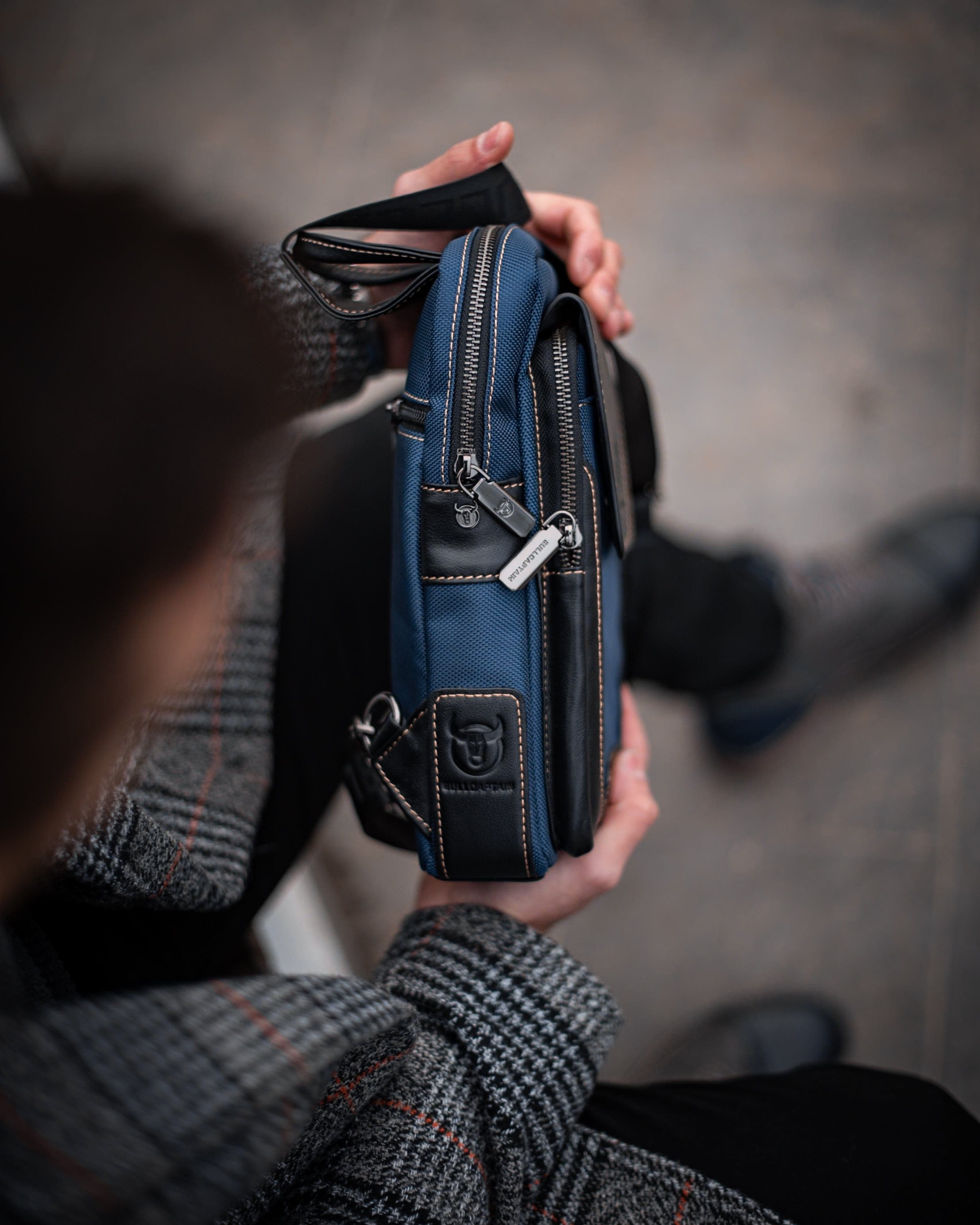 Muška Kožna Torba West - Plava Boja - Muskarac drzi u rukama torbu i pokazuje desnu stranu