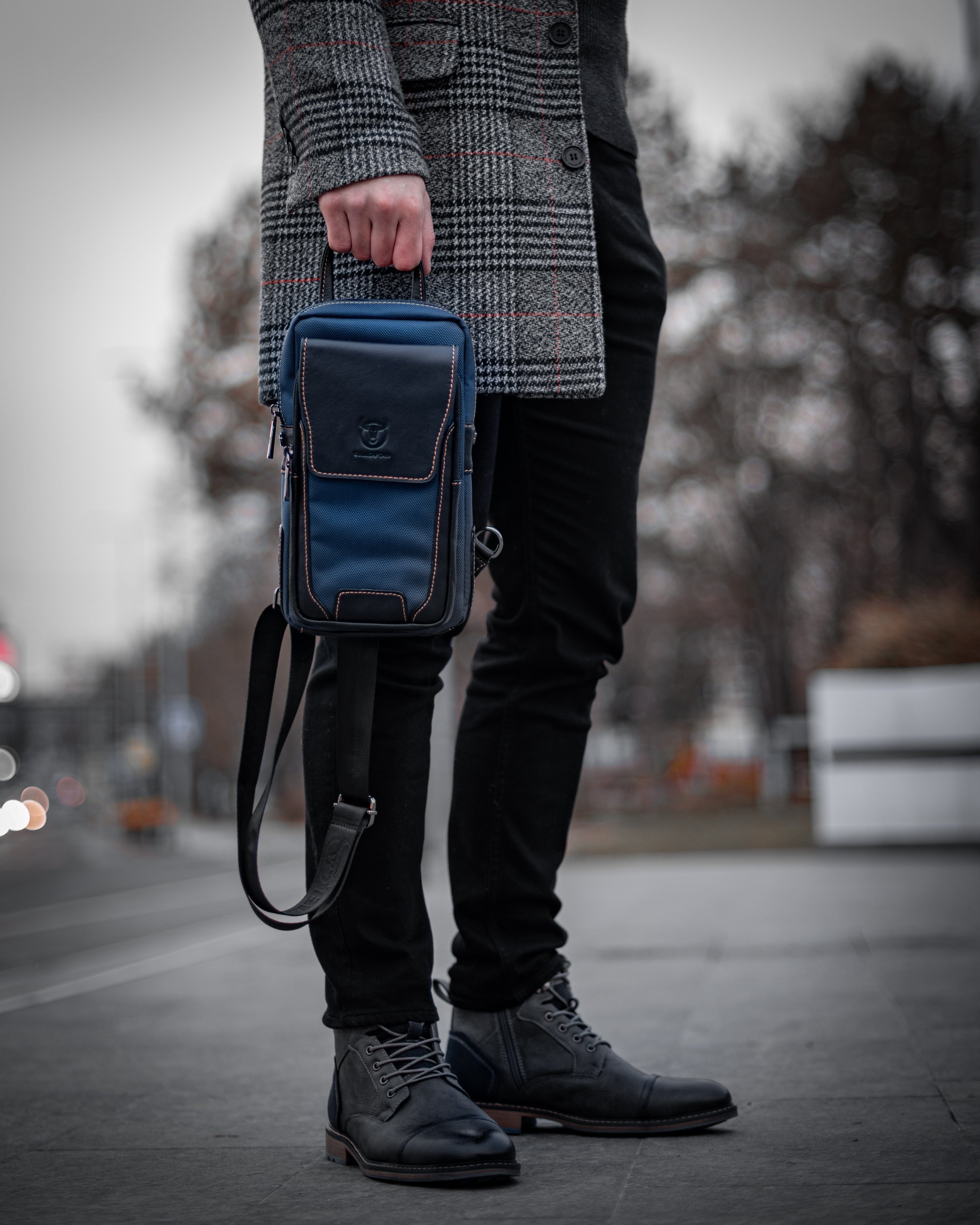 Muška Kožna Torba West - Plava Boja - Muskarac drzi u ruci torbu i pokazuje prednju stranu