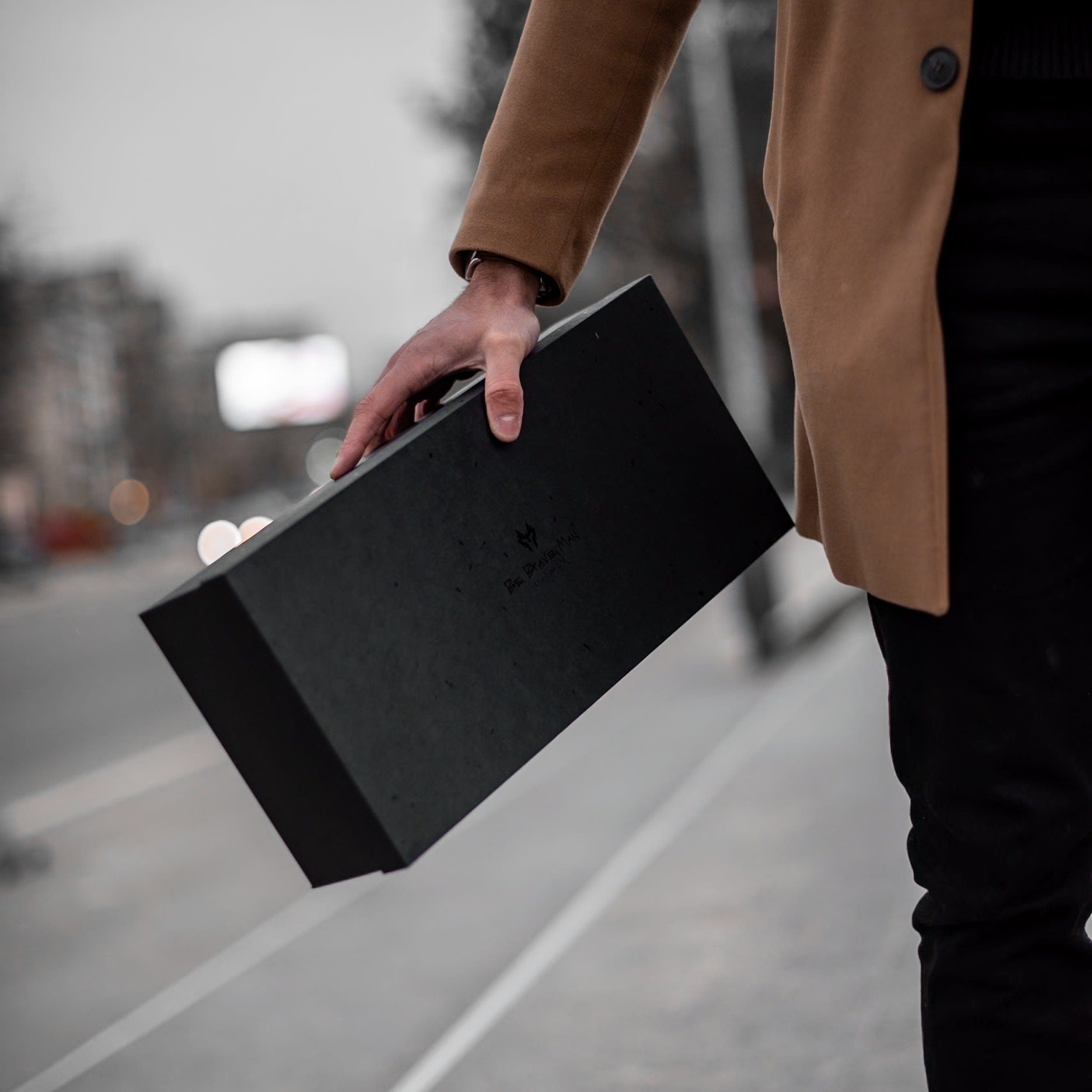 Muskarac drzi u rukama i pokazuje elegantnu kutiju u kojoj se dobija muska kozna torba Morwell