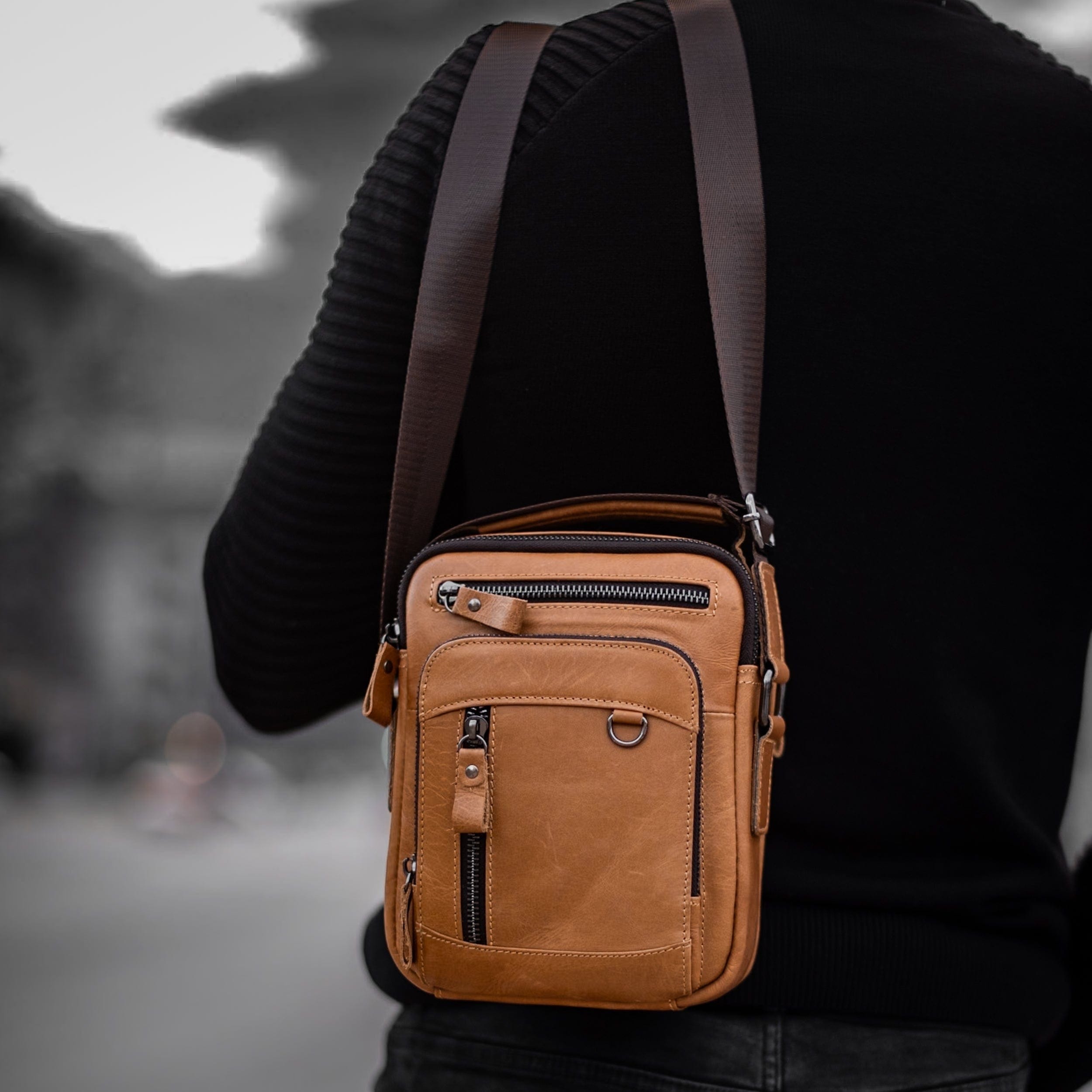 Muška Kožna Torba Morwell - Svetla Braon Boja - Muskarac drzi preko ramena kais torbe i pokazuje prednju stranu