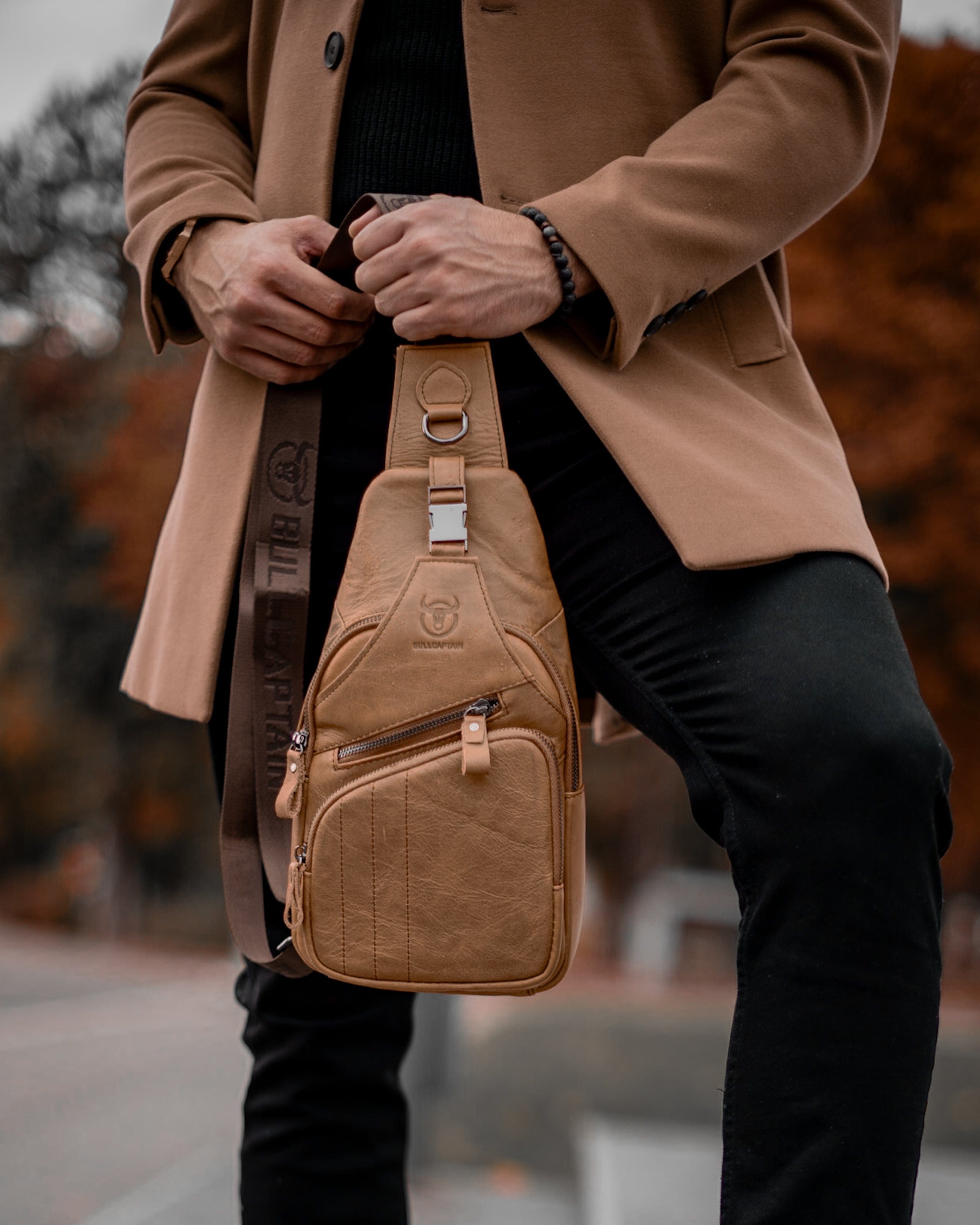 Muška Kožna Torba Tour - Svetla Braon Boja - Muskarac drzi u rukama torbu i pokazuje prednju stranu