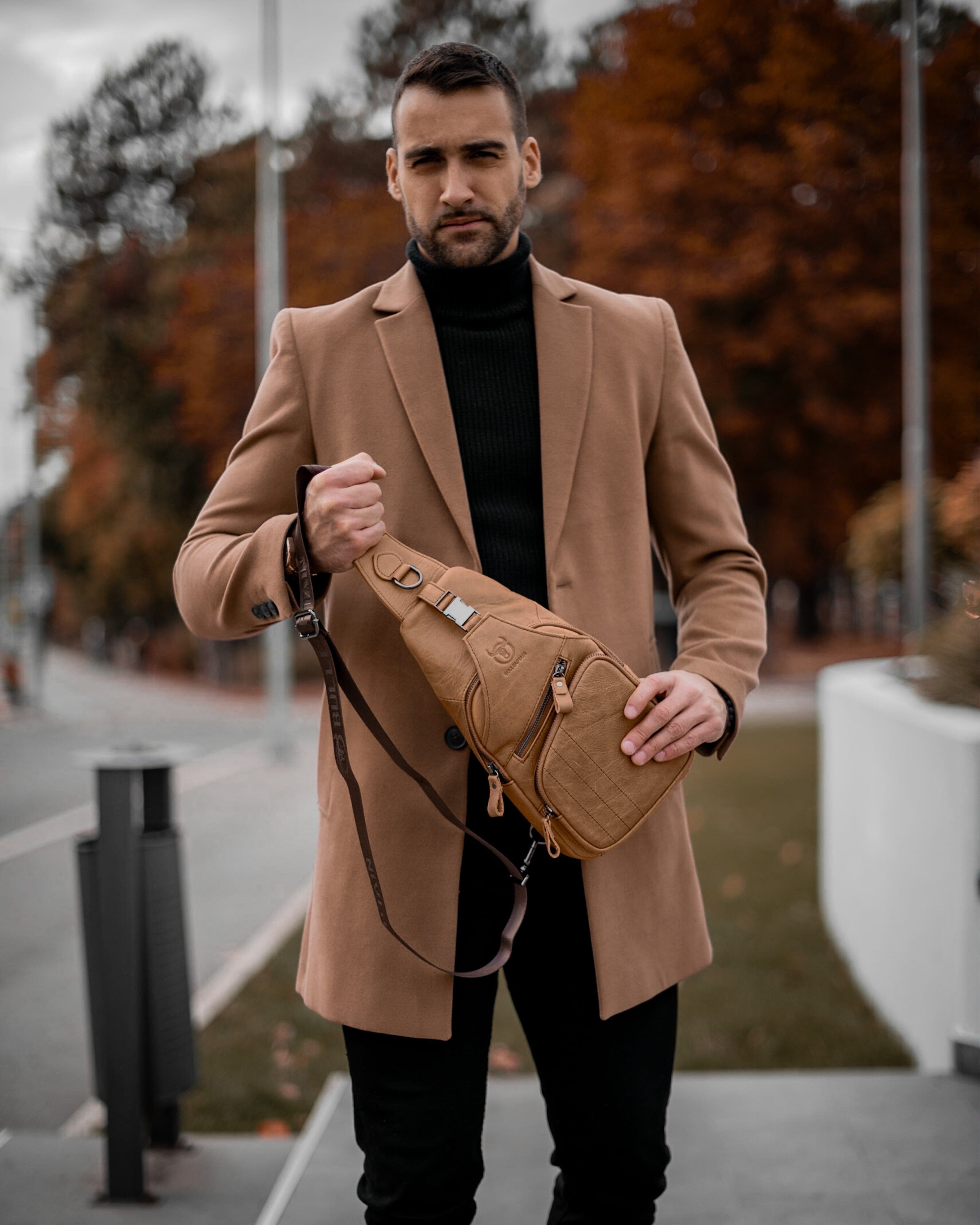 Muška Kožna Torba Tour - Svetla Braon Boja - Muskarac drzi u rukama i pokazuje prednju stranu torbe