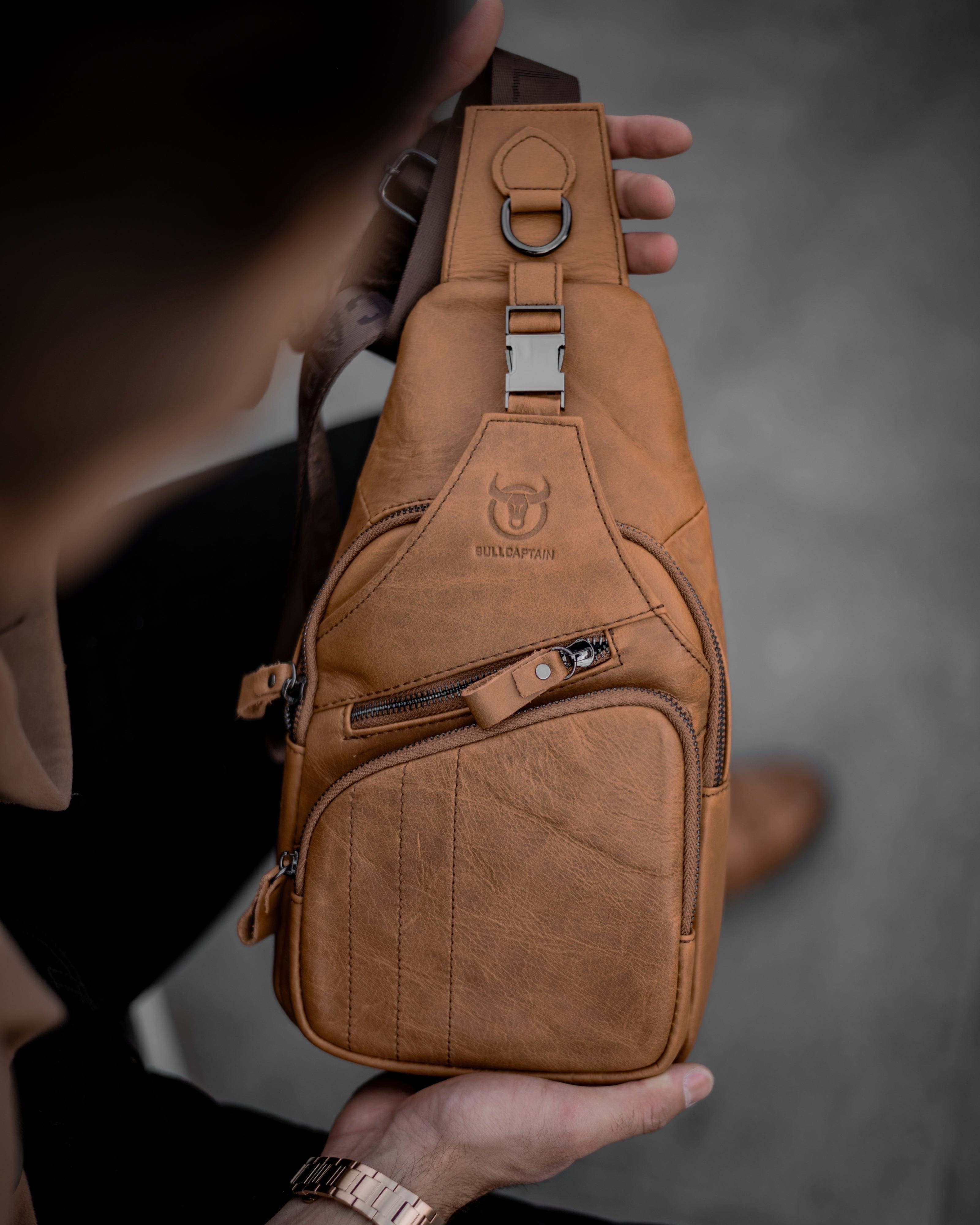 Muška Kožna Torba Tour - Svetla Braon Boja - Muskarac drzi u rukama torbu i izbliza pokazuje prednju stranu