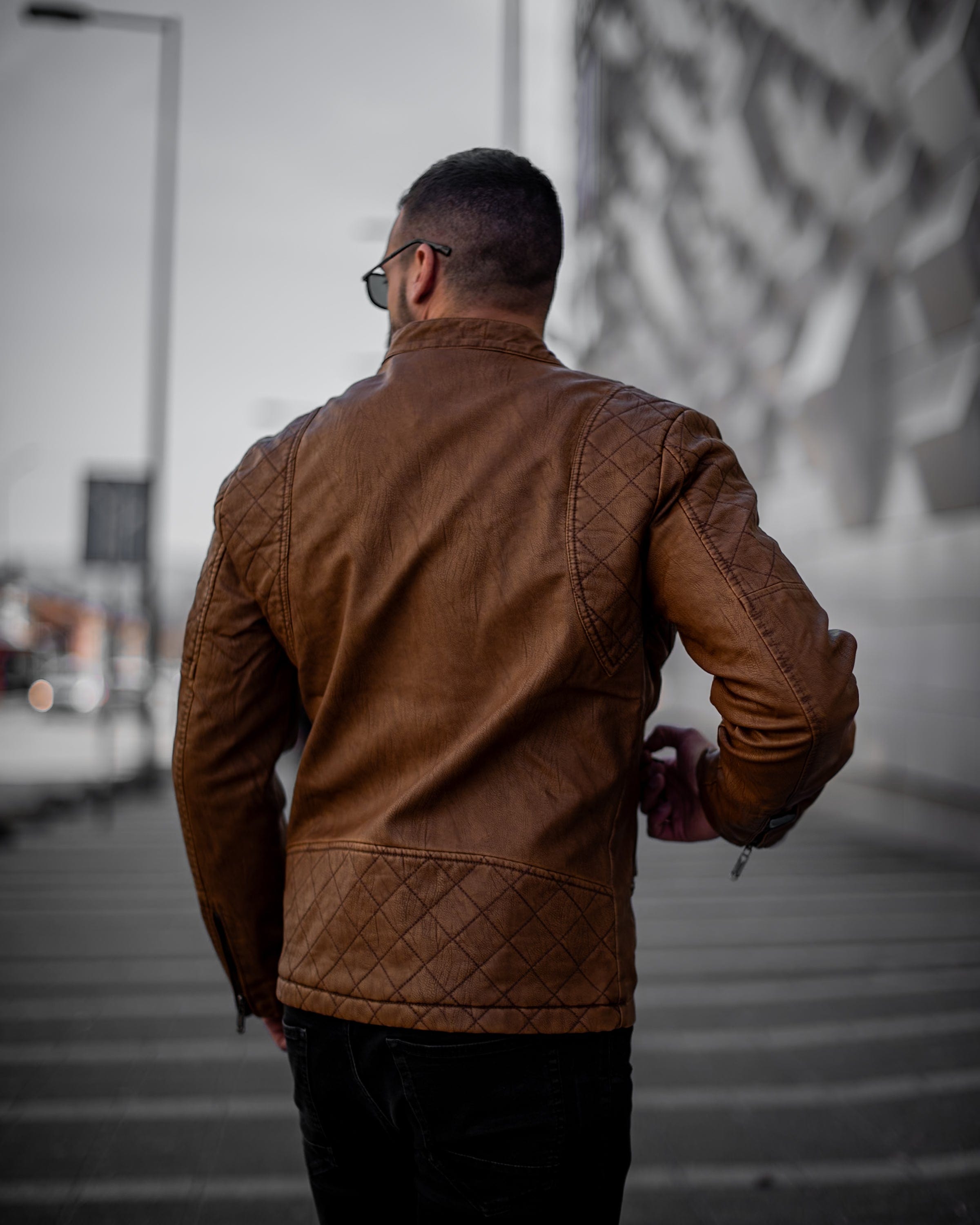 Muskrac nosi musku koznu letnju jaknu u braon boji i prikazuje zadnju bocnu stranu jakne. Najbolja cena i prodaja u Srbiji. Model 3