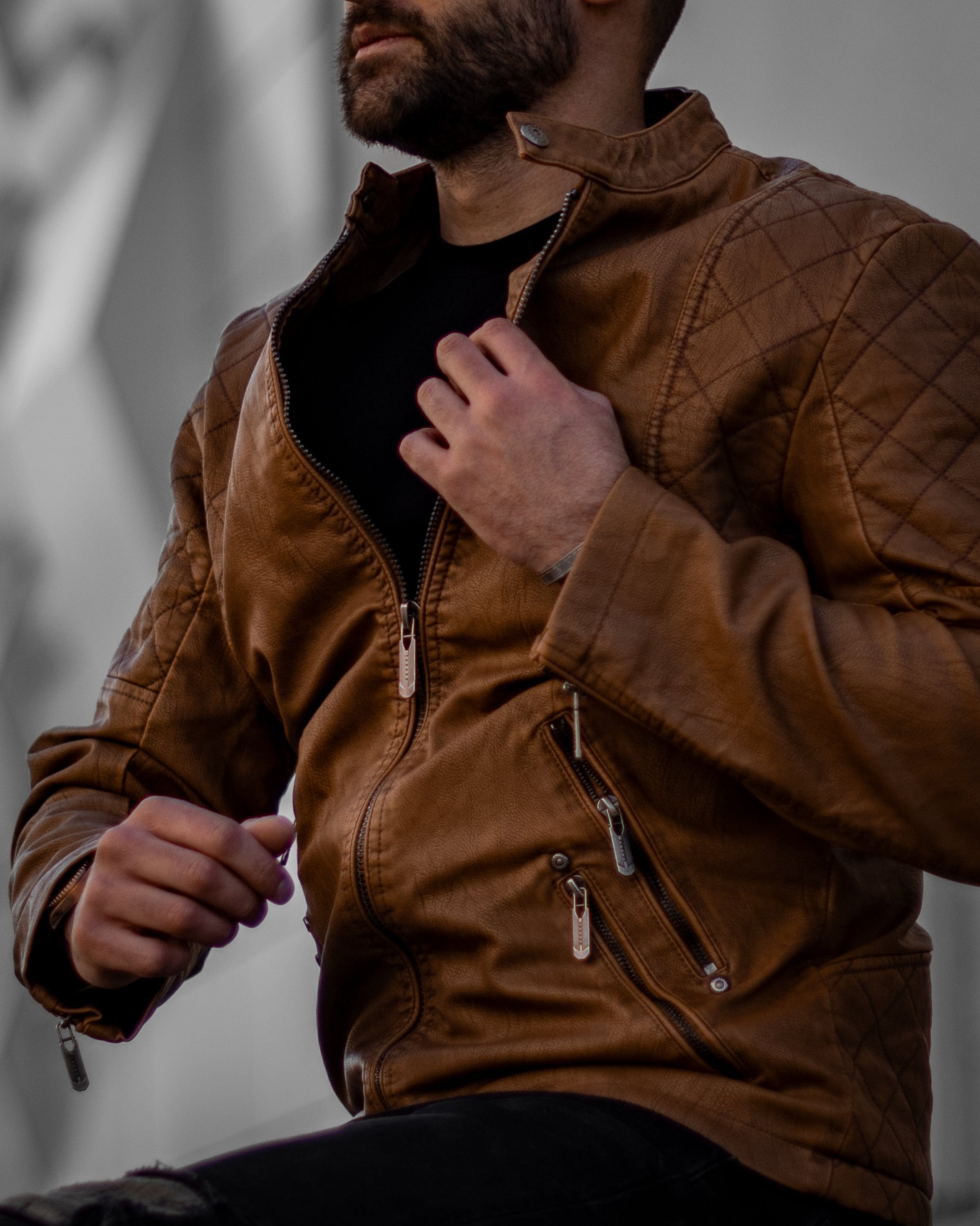 Muskrac nosi i izbliza pokazuje prednju bocnu stranu muske kozne letnje jakne u braon boji. Najbolja cena i prodaja u Srbiji. Model 3