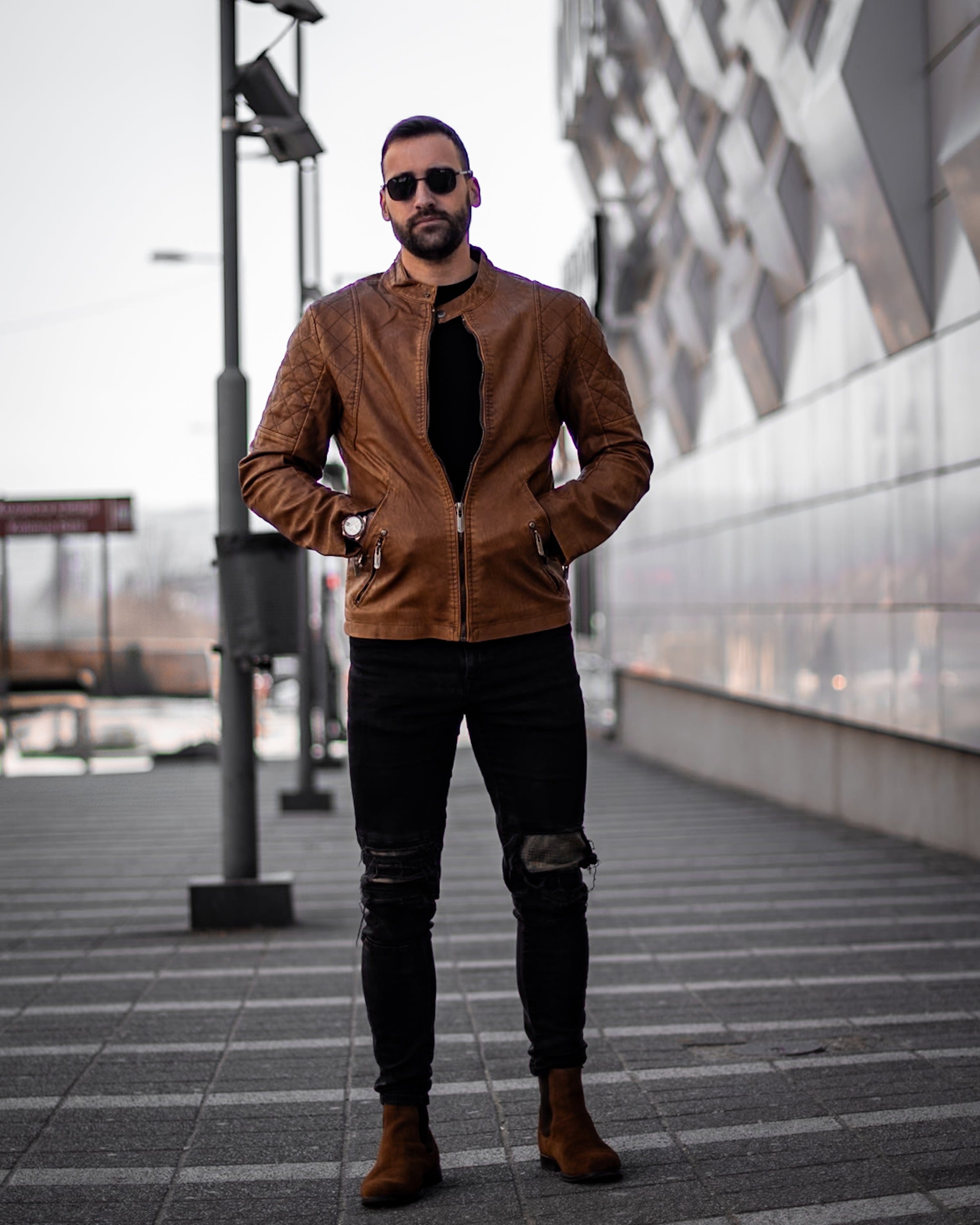 Muskrac nosi musku koznu letnju jaknu u braon boji i prikazuje otkopcanu prednju stranu jakne. Najbolja cena i prodaja u Srbiji. Model 3