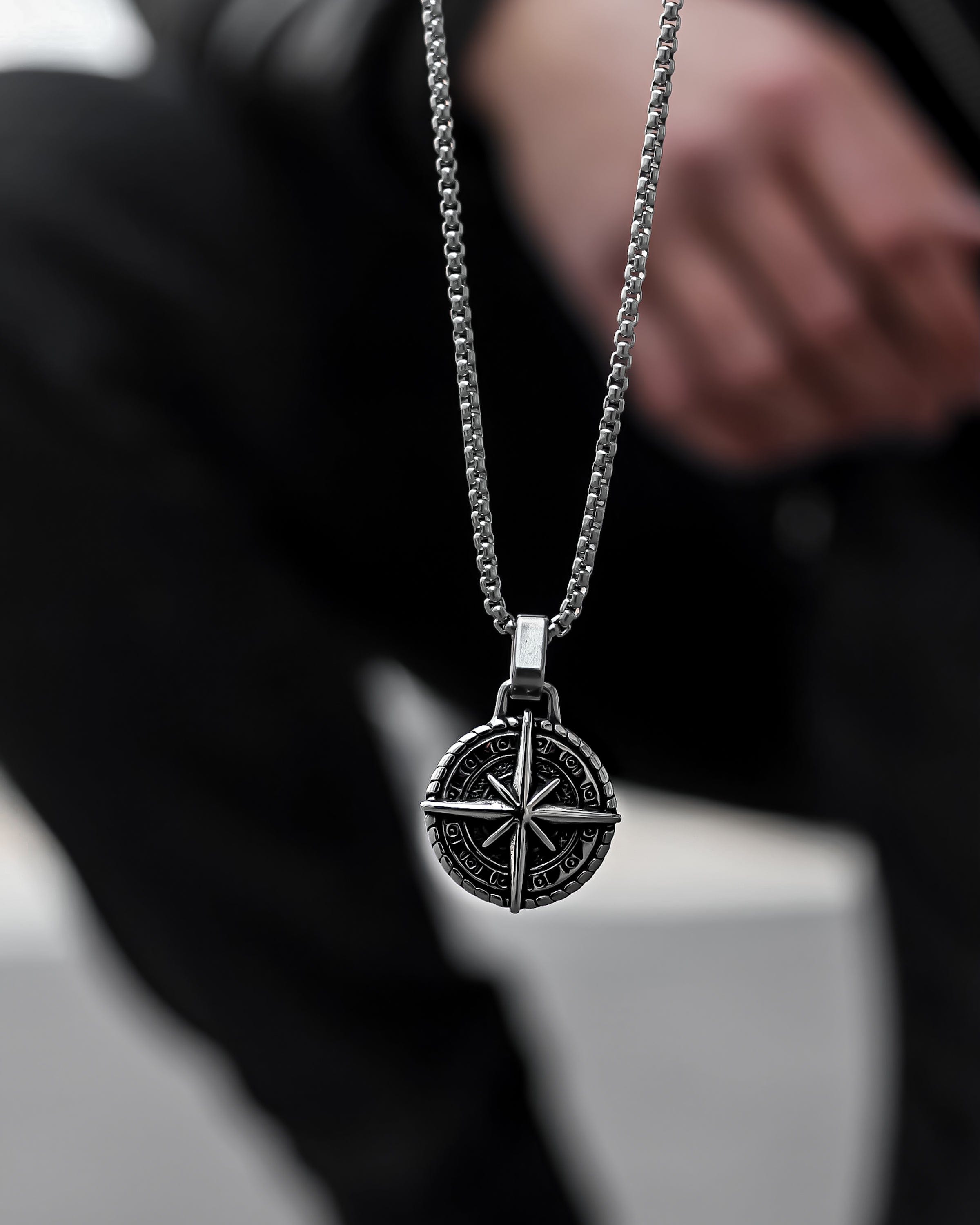 Muskarac drzi lanac i pokazuje privezak muske ogrlice North Star. Privezak i lanac HIRUSKI CELIK, srebrna boja, Najbolja cena i prodaja u Srbiji, model 12
