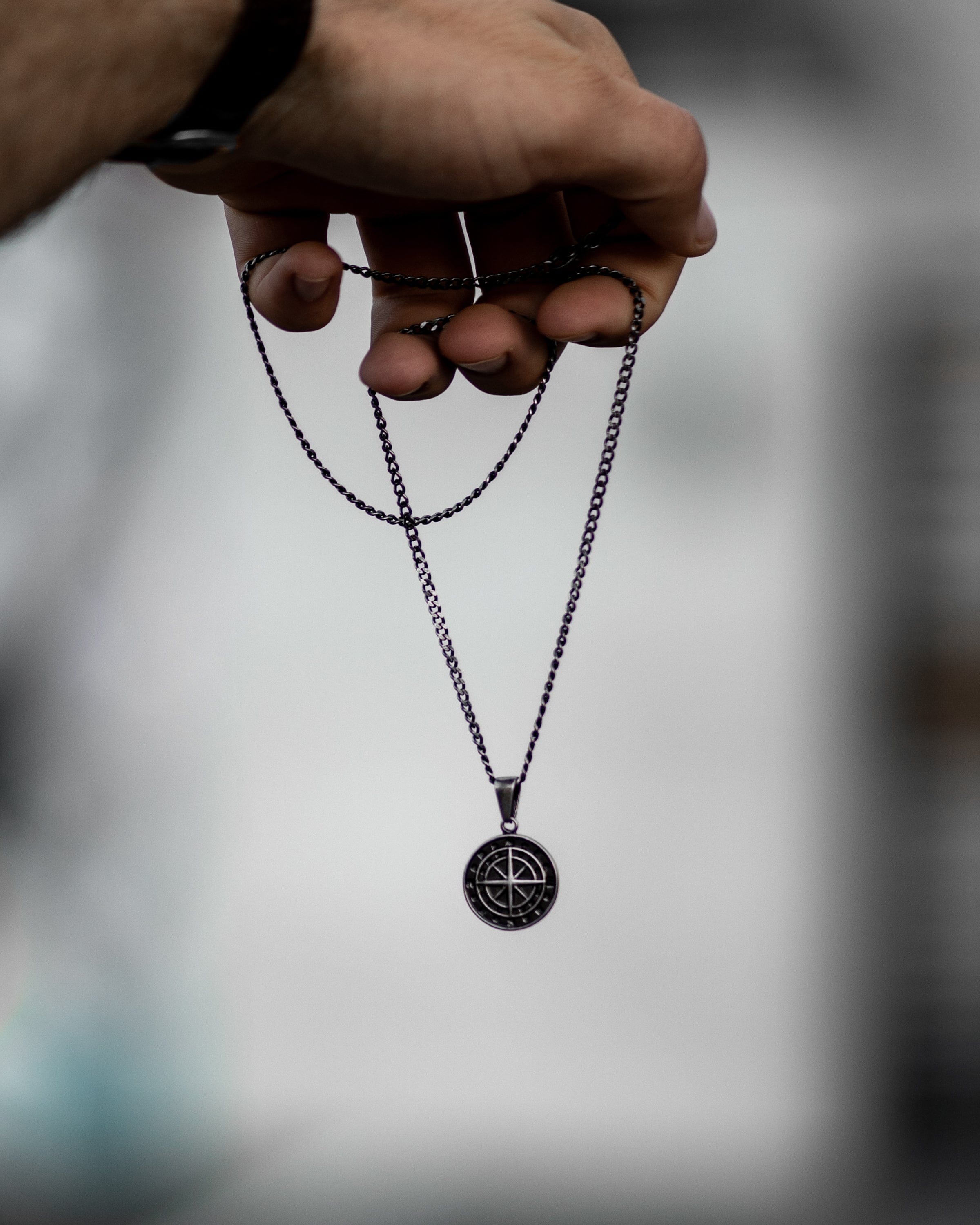 Muskarac detaljno pokazuje privezak i lanac muske ogrlice Black Journey, Privezak i lanac HIRUSKI CELIK, crna boja celika, Najbolja cena i prodaja u Srbiji, model 14