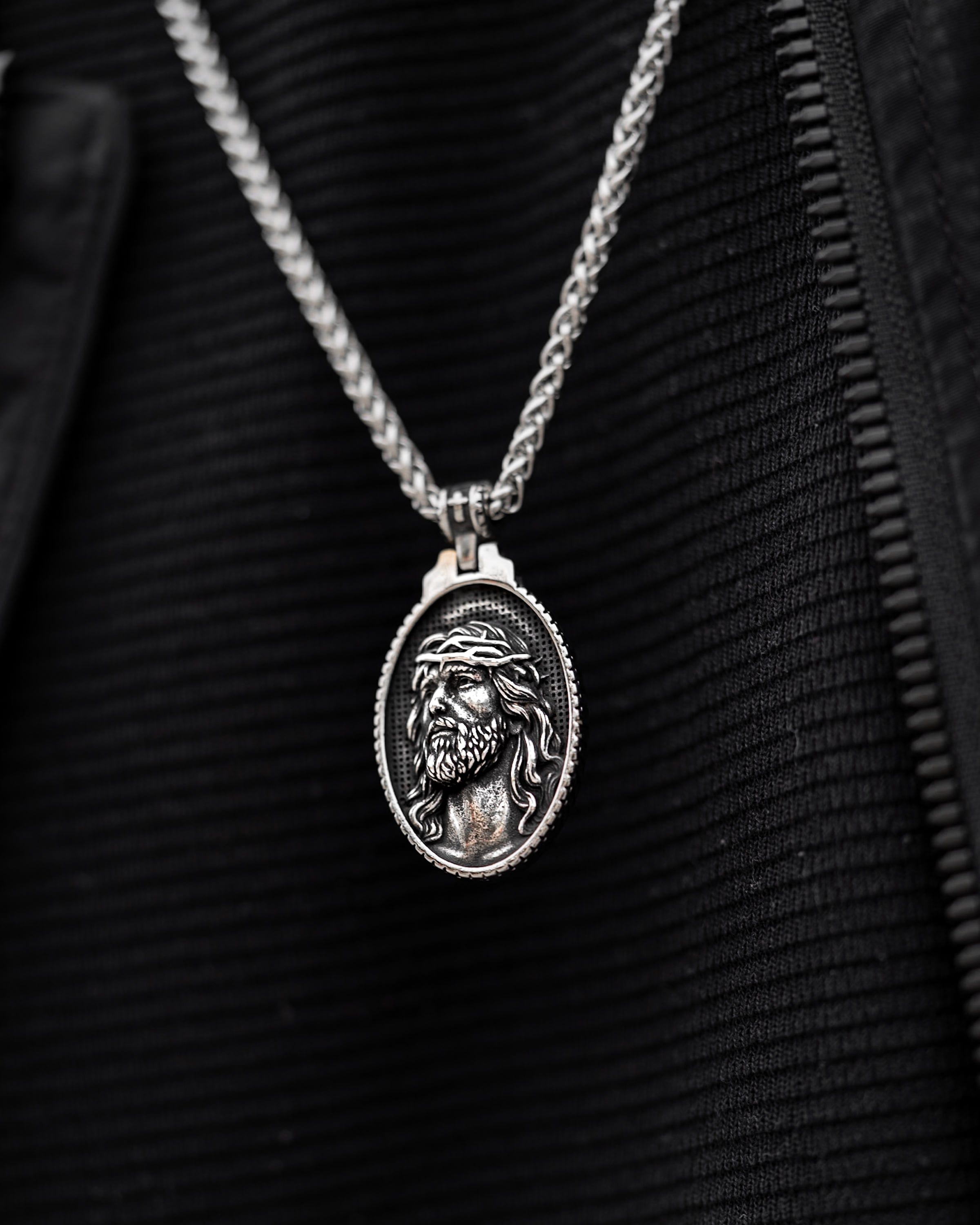 Muskarac nosi i izbliza pokazuje prednju stranu priveska muske ogrlice Jesus of Nazareth, Privezak i lanac HIRUSKI CELIK, srebrna boja, Najbolja cena i prodaja u Srbiji, model 21