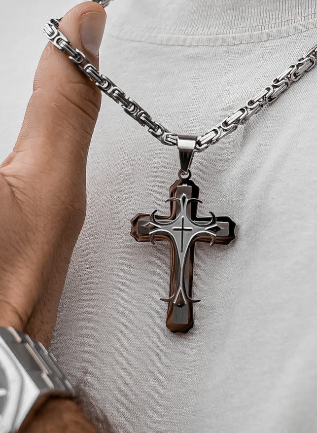 Muskarac detaljno pokazuje izbliza privezak muske ogrlice Iron Cross, Privezak i lanac HIRUSKI CELIK, srebrna boja, Najbolja cena i prodaja u Srbiji, model 23