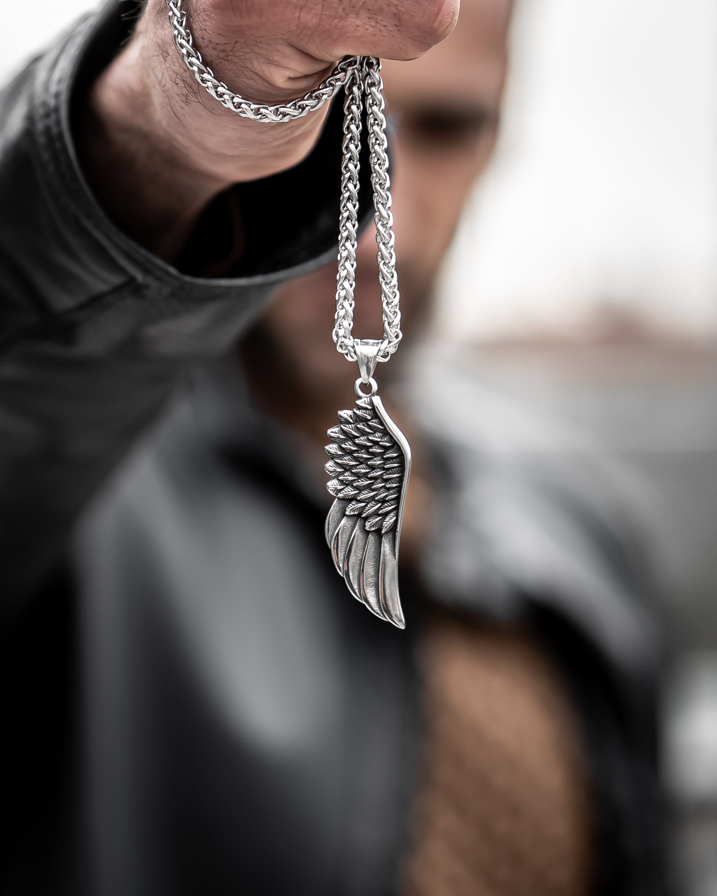 Muskarac drzi u ruci musku ogrlicu Freedom, Privezak i lanac HIRUSKI CELIK, srebrna boja, Najbolja cena i prodaja u Srbiji, model 6