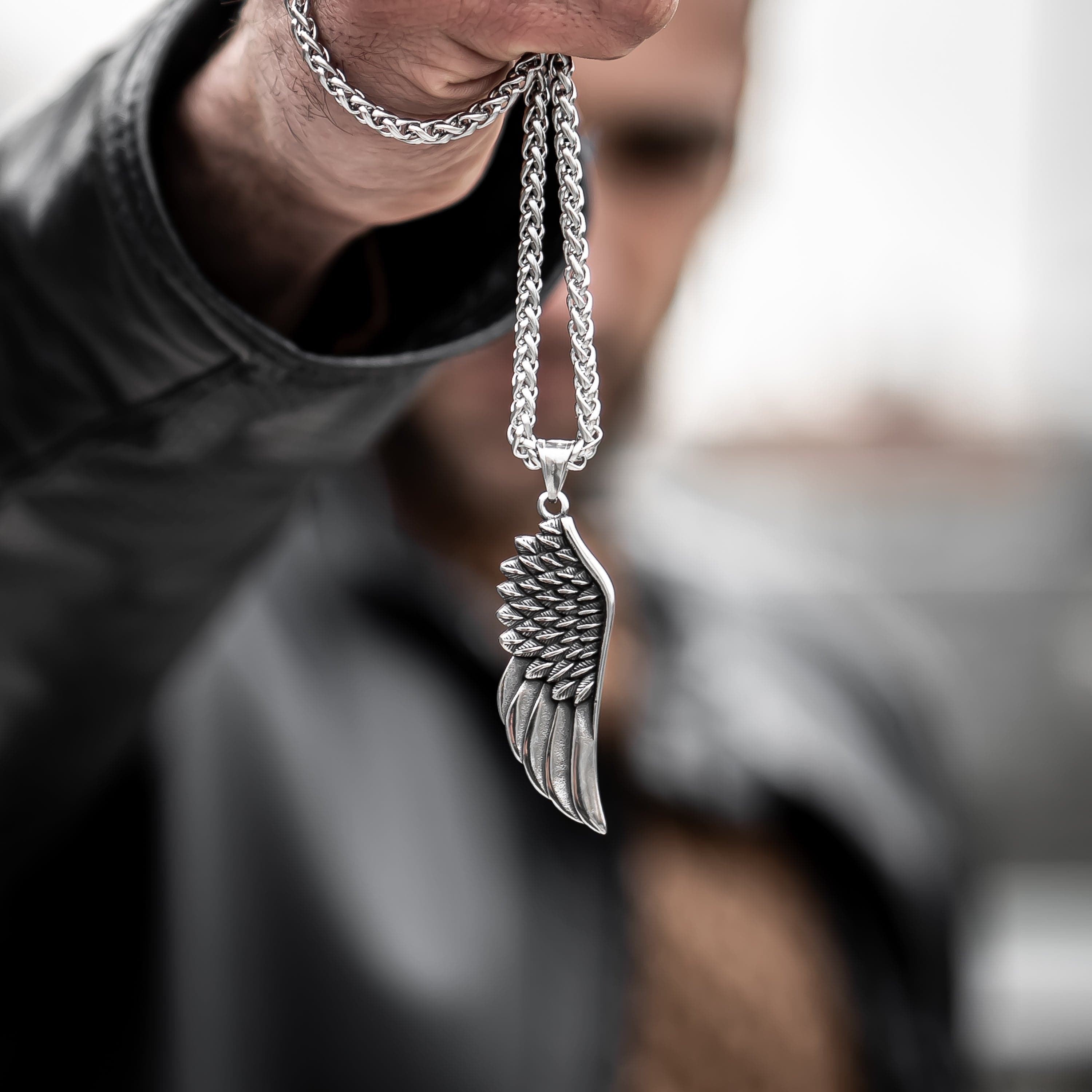 Muskarac drzi u ruci musku ogrlicu Freedom, Privezak i lanac HIRUSKI CELIK, srebrna boja, Najbolja cena i prodaja u Srbiji, model 6