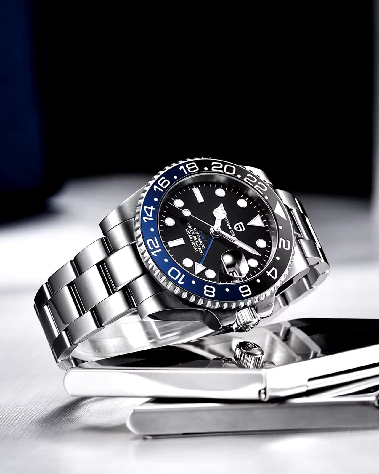 Muški GMT sat Pagani Design PD-1662 “Batman” sa čeličnom narukvicom na minimalističkoj pozadini