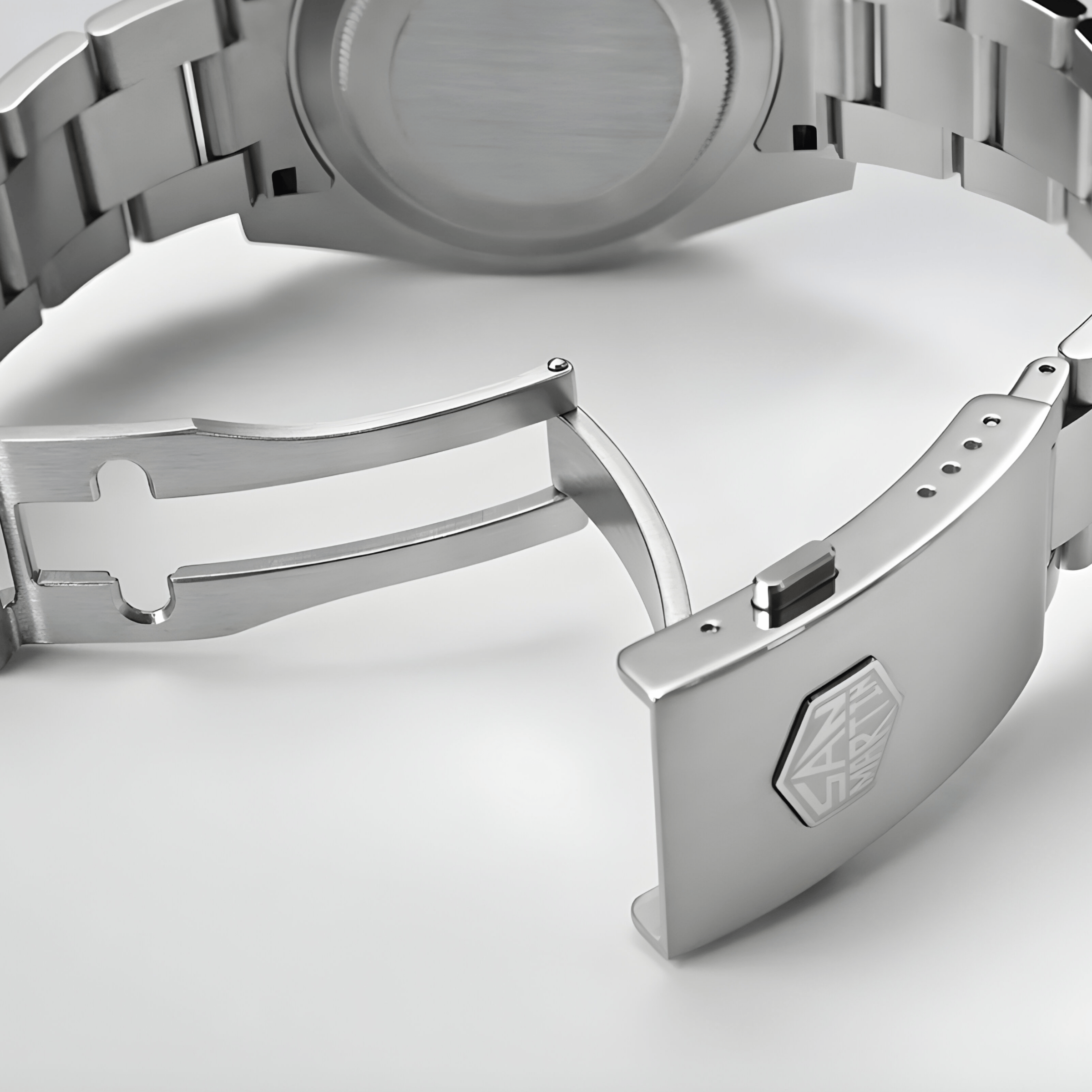 Otvorena čelična kopča metalne narukvice sata San Martin SN0118 sa vidljivim sigurnosnim mehanizmom i ugraviranim logotipom